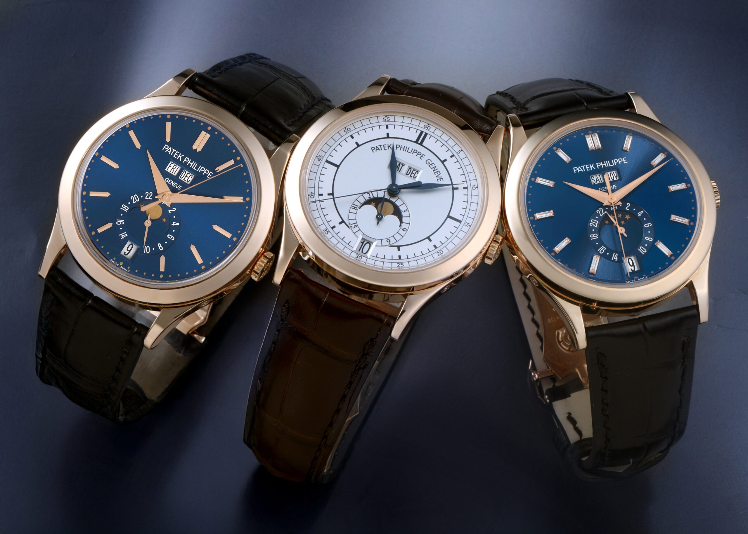 Three Patek Philippe Annual Calendar watches in 18k rose gold reference 5396R with blue and silver dials.Patek Philippe invented the Annual Calendar complication in 1996. The modern Reference 5396R showcases the maison's unrivaled mastery of elegant, highly legible dial layouts.