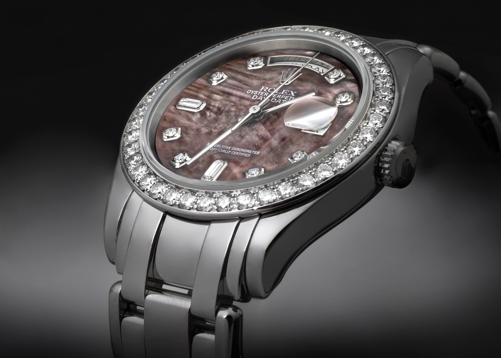 Close-up of a luxurious white gold or platinum Rolex Pearlmaster 18946 watch, featuring a diamond-set bezel, a unique dark mother-of-pearl dial, and diamond hour markers.