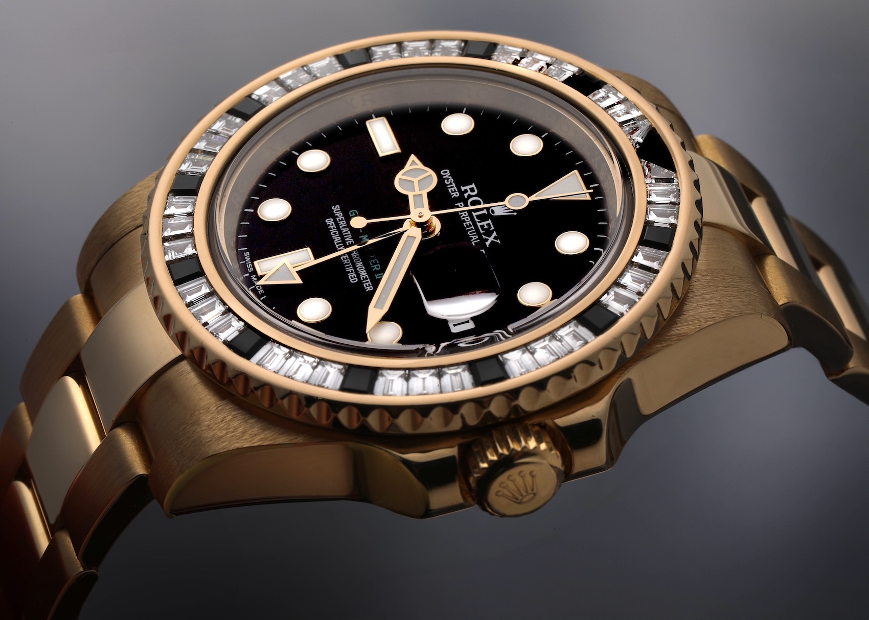 Close-up of a luxurious gold Rolex GMT-Master II watch featuring a black dial, luminous hour markers, and a unique bezel set with alternating baguette diamonds and black onyx