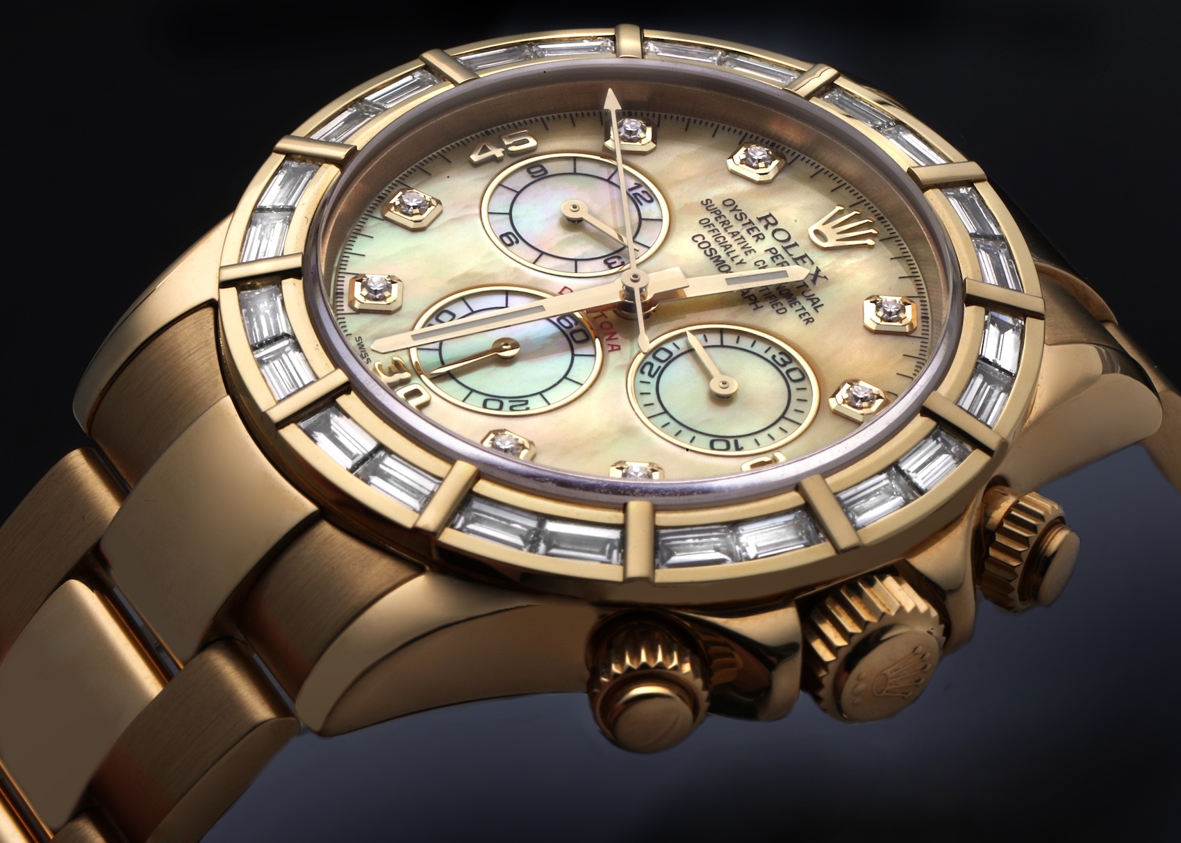 Close-up of a luxurious gold Rolex Daytona model 116568 chronograph watch with a mother-of-pearl dial, diamond hour markers, and a bezel set with baguette diamonds.