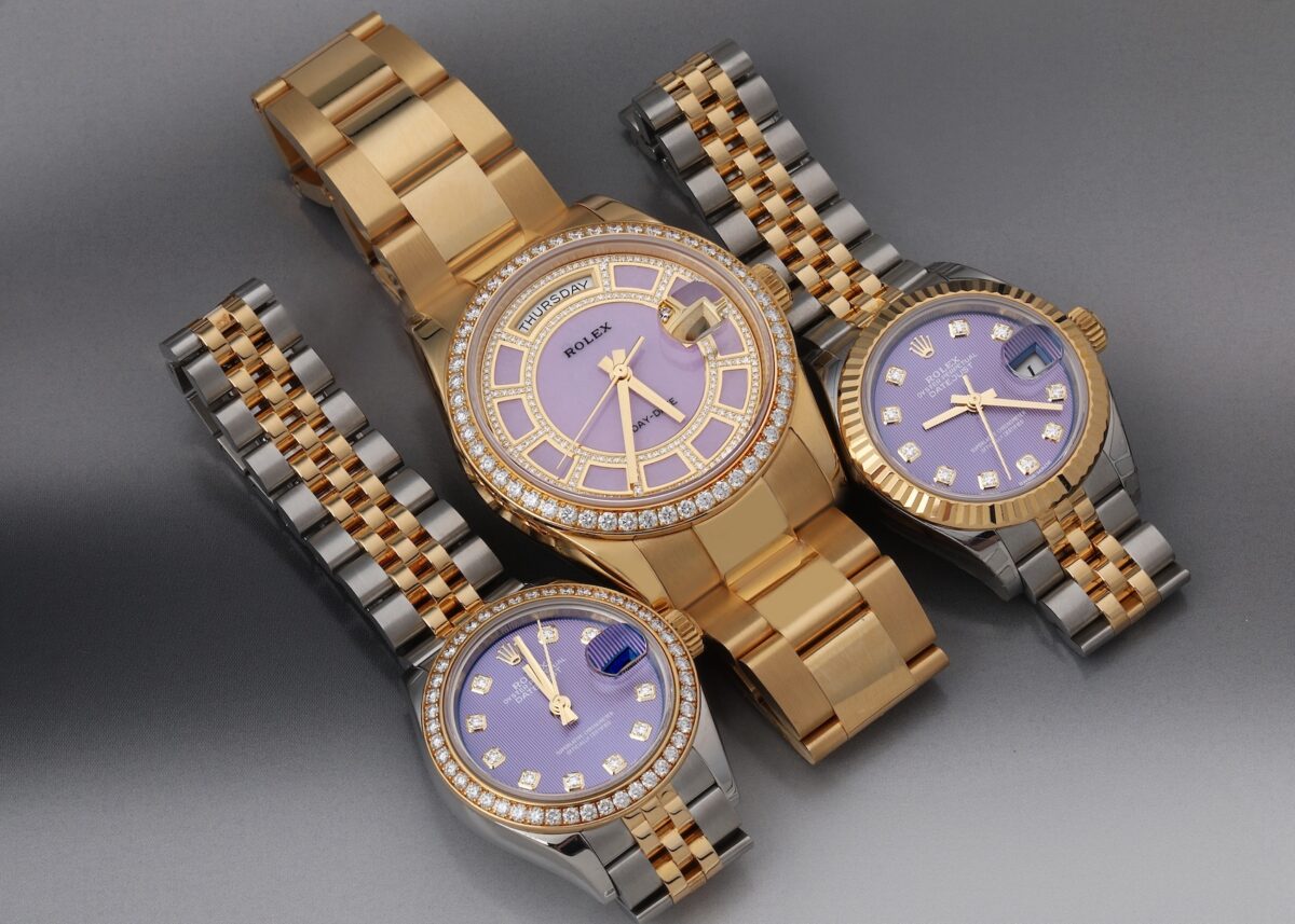 Three luxury Rolex watches featuring lavender or purple dials with diamond hour markers and diamond-set bezels, including a yellow gold Day-Date and two Two-Tone Datejusts.