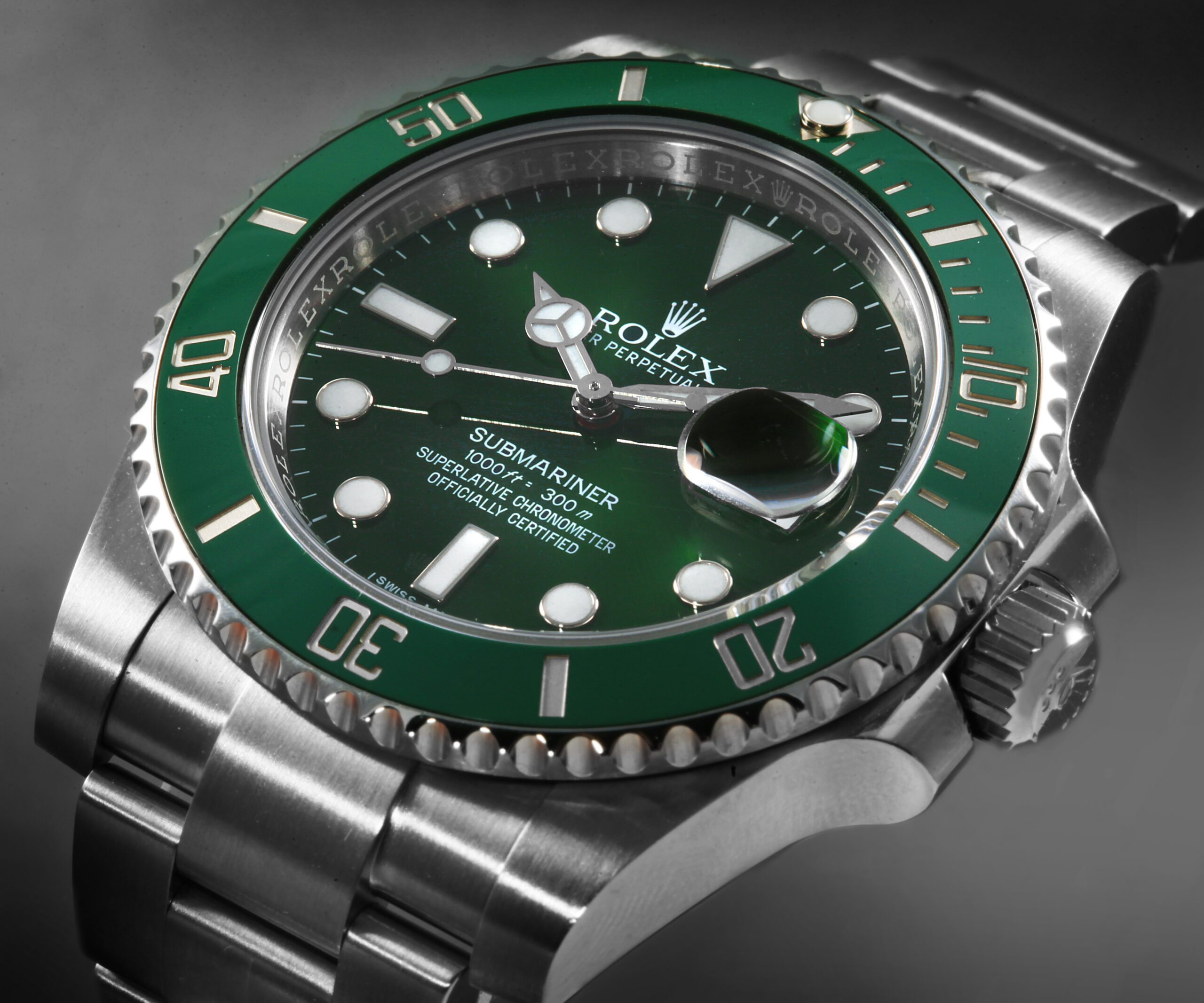 A close-up, angled view of the discontinued Rolex Submariner "Hulk" 116610LV, showcasing its vibrant green sunburst dial and matching green bezel.