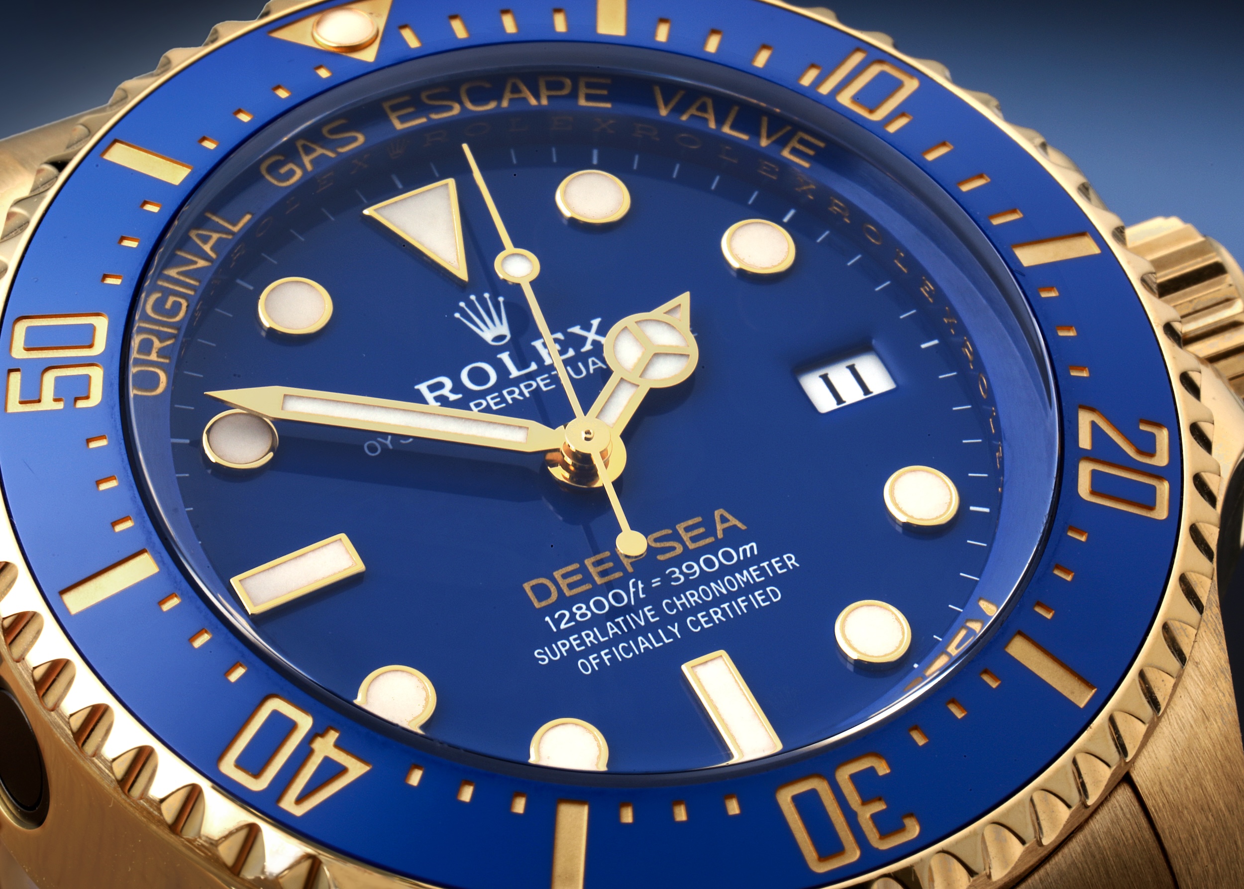 Close-up shot of the Rolex Deepsea 136668LB, an 18ct yellow gold dive watch featuring a vibrant blue ceramic bezel, a matching blue dial, and the signature 'RING LOCK SYSTEM' text.