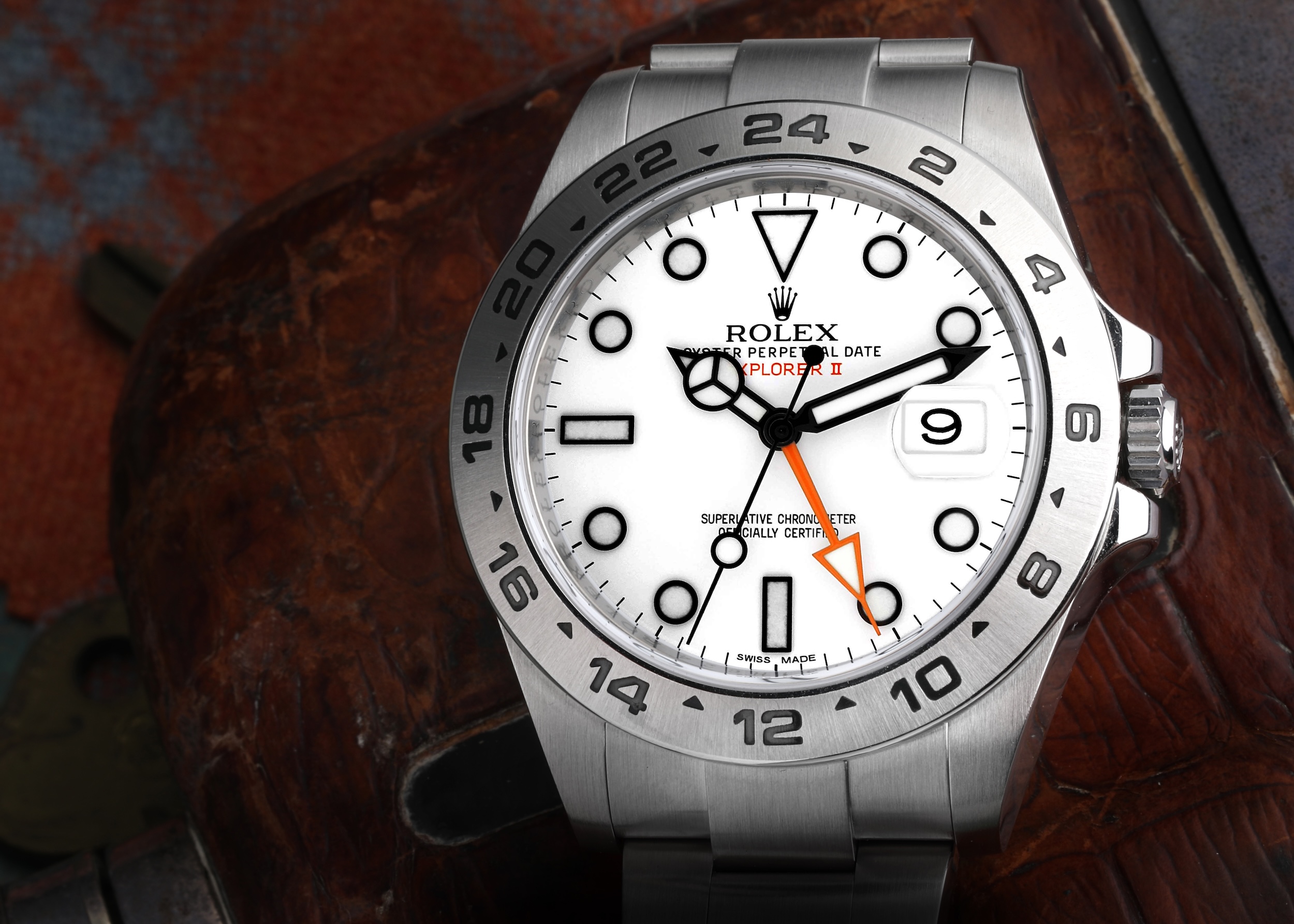 Rolex Explorer II 'Polar' with a white dial, black hour markers, and an orange 24-hour hand, on a stainless steel Oyster bracelet.