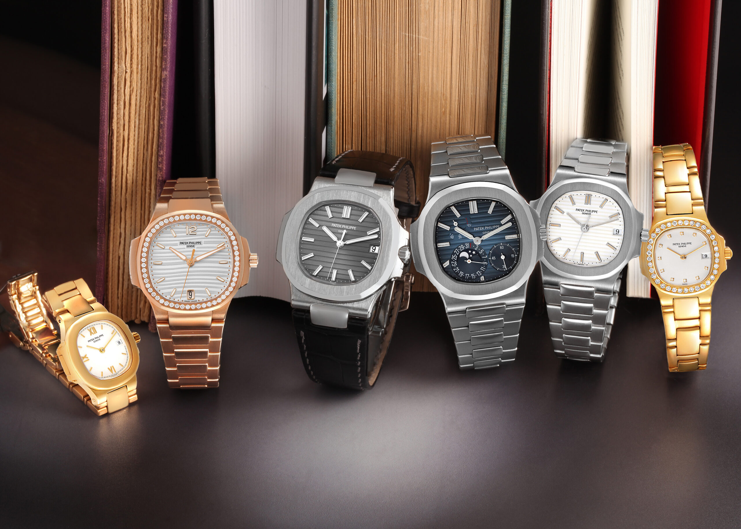 A lineup of various Patek Philippe watches, including iconic Nautilus models in rose gold, steel, and yellow gold, highlighting the diversity of the collection.