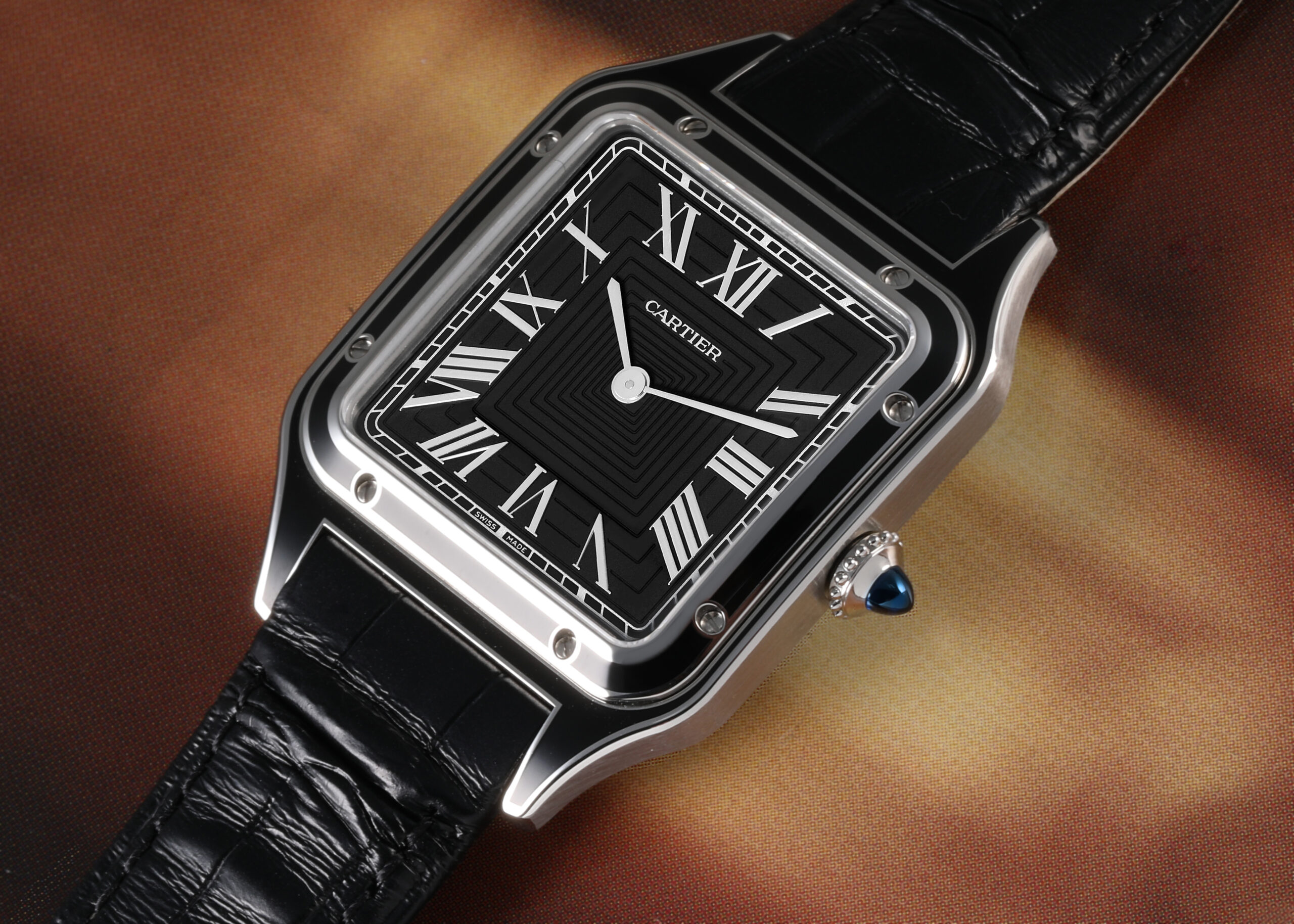Close-up of a modern Cartier Santos-Dumont watch with a black dial and bezel, showcasing its iconic square case, Roman numerals, and exposed screws.