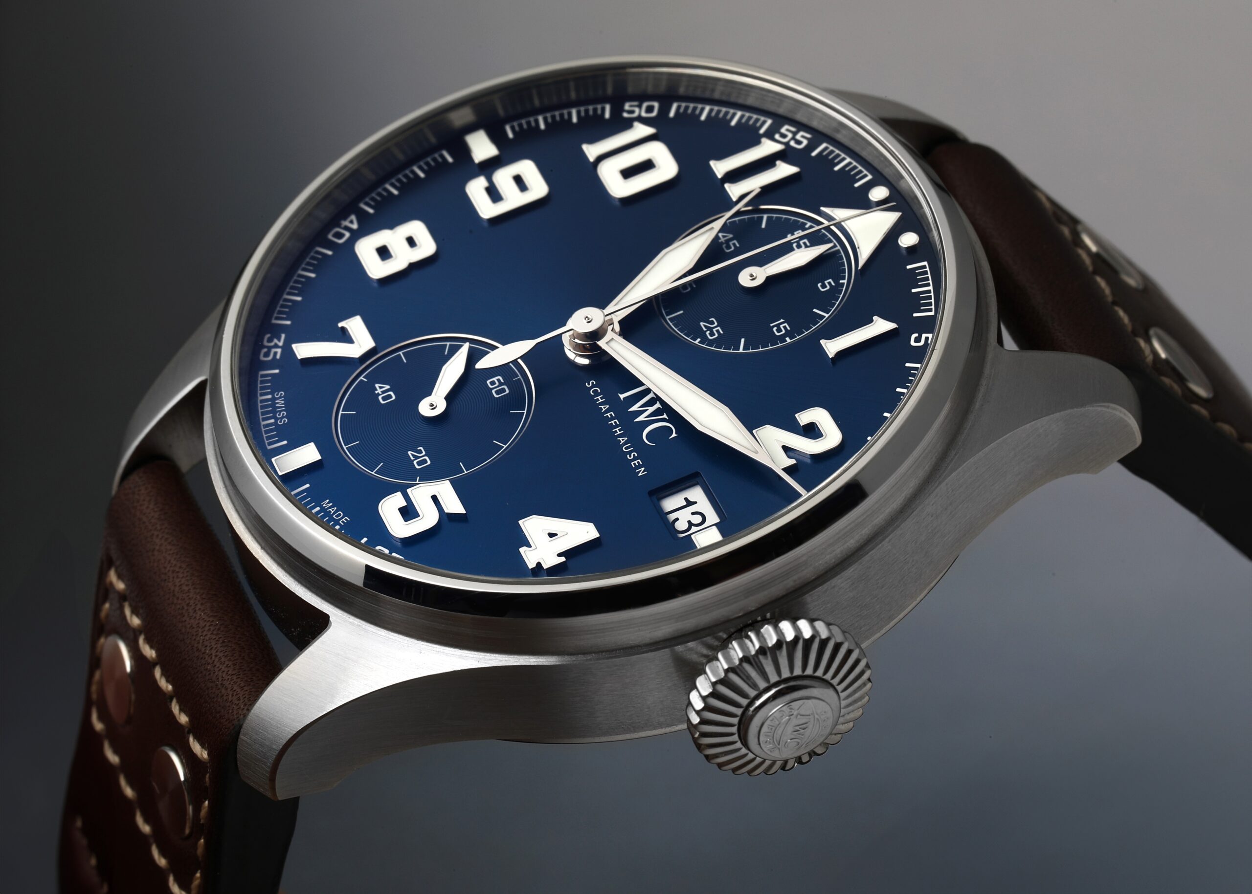 Detailed angle view of the IWC Big Pilot's Watch 'Le Petit Prince' edition, highlighting its large blue dial, luminous Arabic numerals, and distinctive onion crown.