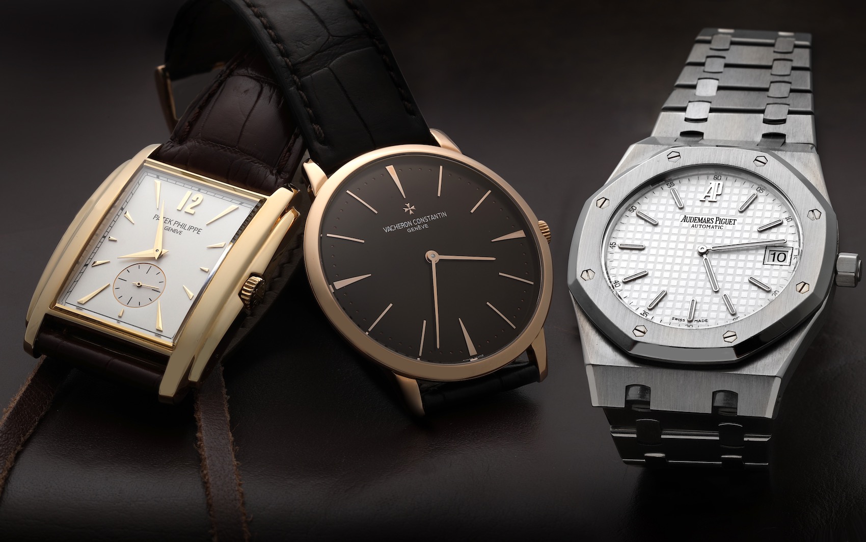 A collection of three luxury watches, showing the variety in dress watch styles from the rectangular Patek Philippe Gondolo and round Vacheron Constantin Patrimony to the integrated bracelet of the Audemars Piguet Royal Oak.