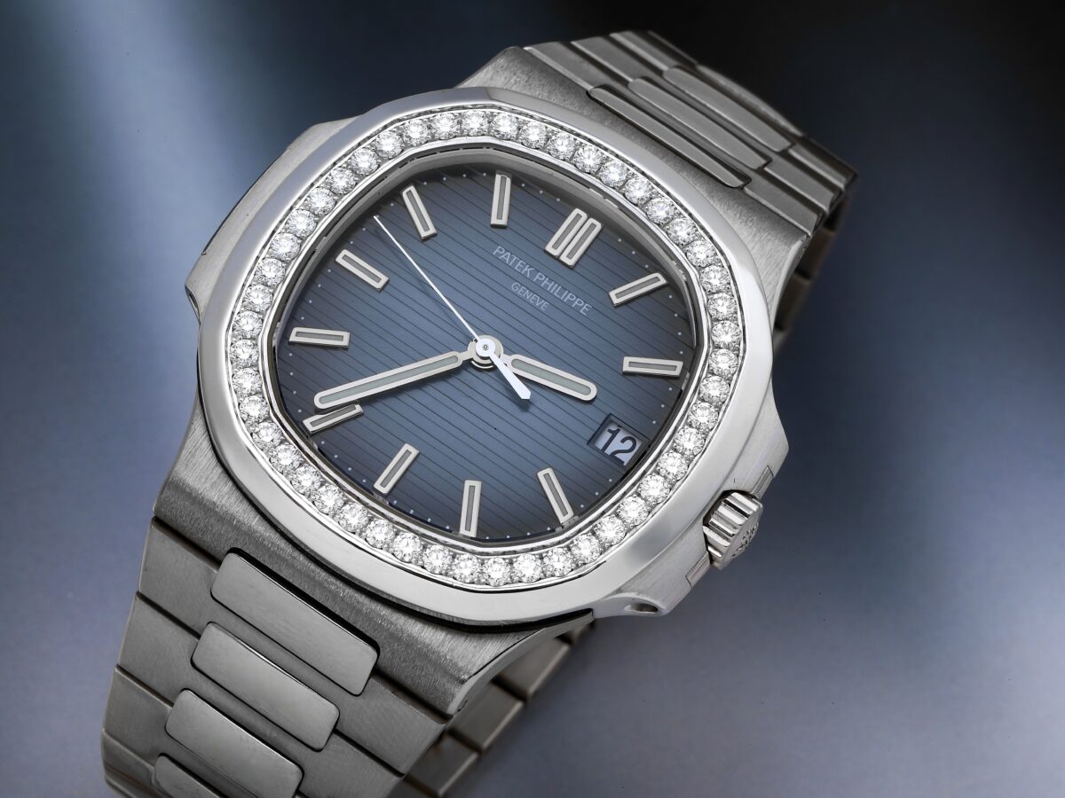 Patek Philippe Nautilus 5713 men's watch in white gold, featuring a factory diamond bezel and a blue dial.