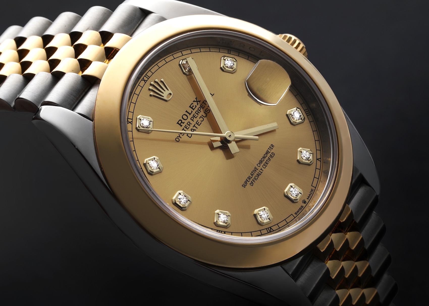 A close-up view of a Rolex Datejust 41, featuring a two-tone steel and yellow gold Jubilee bracelet, a fluted yellow gold bezel, and a champagne-colored dial with diamond hour markers.