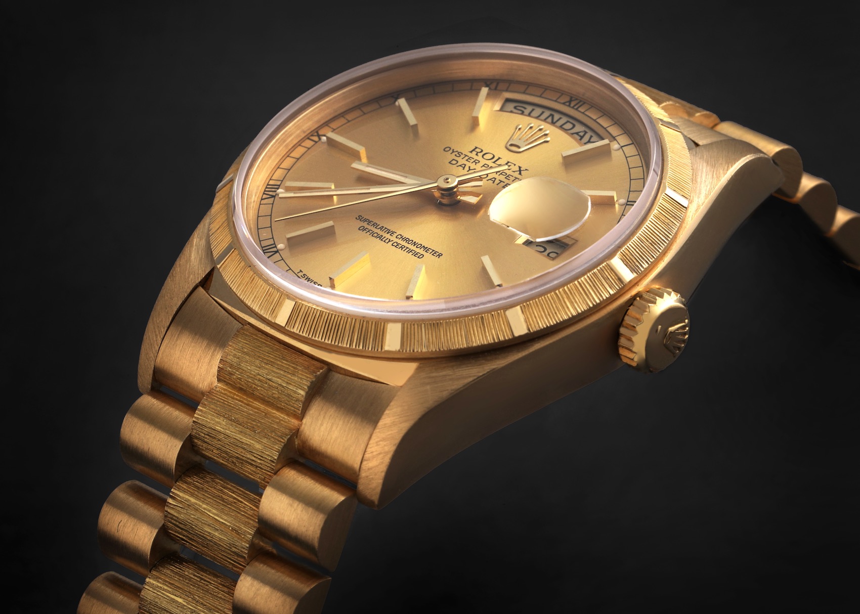 A close-up view of a vintage Rolex Day-Date President Yellow Gold Bark Finish, showcasing its yellow gold case and President bracelet with the distinctive "bark" texture on the bezel and center links.