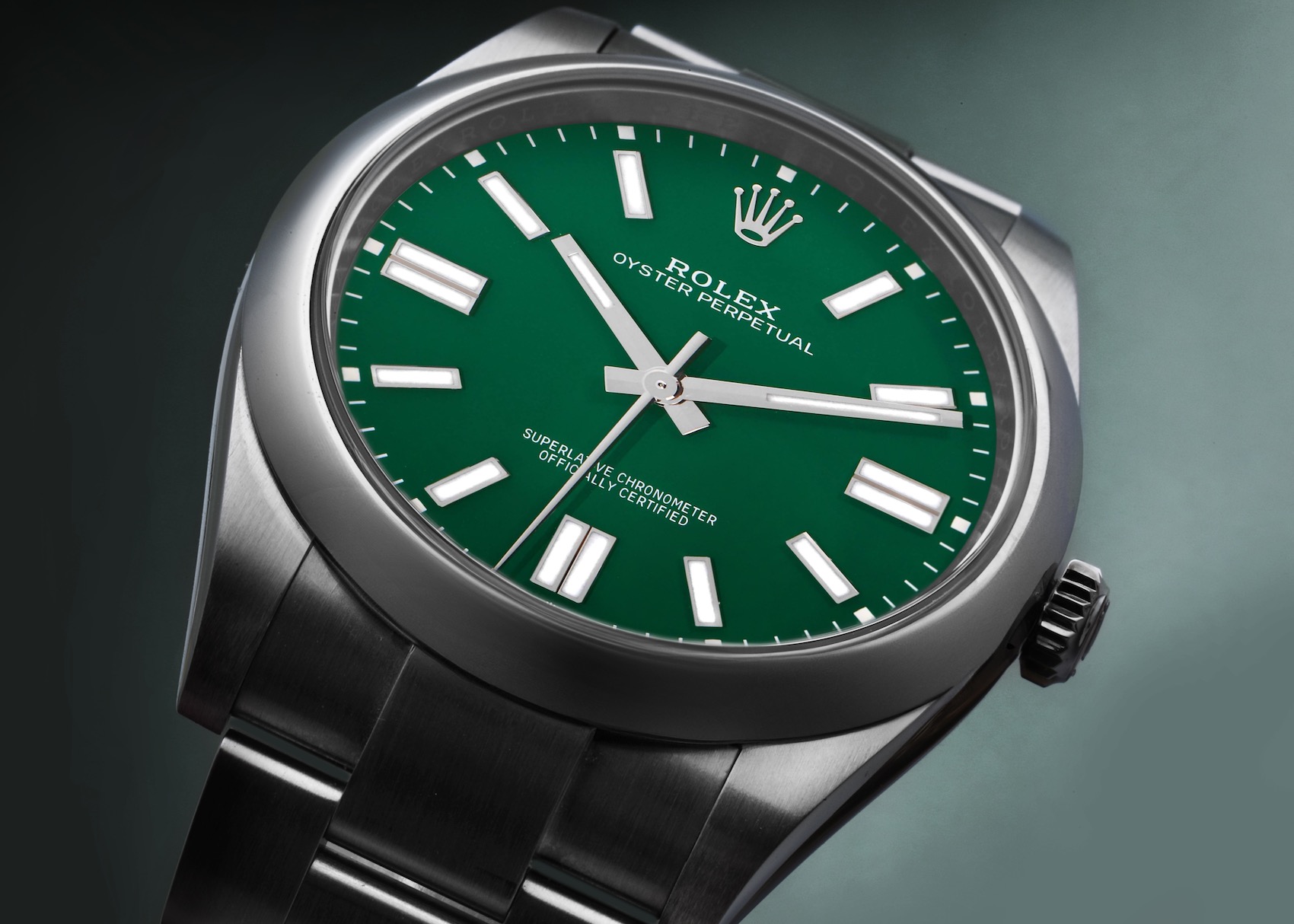 A detailed view of a Rolex Oyster Perpetual 41 with a vibrant green lacquered dial, its polished stainless steel case and Oyster bracelet.