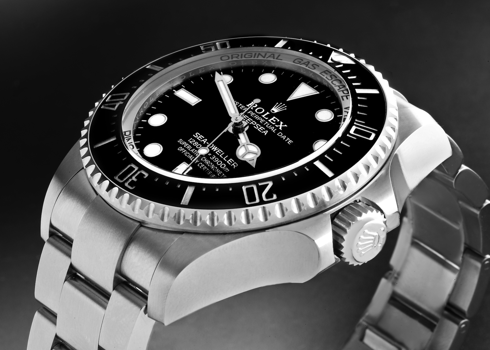 A stainless steel Rolex Sea-Dweller Deepsea reference 116660 is photographed up close, featuring a black dial with a date window, a unidirectional black Cerachrom bezel, and a helium escape valve visible on the side of the case.