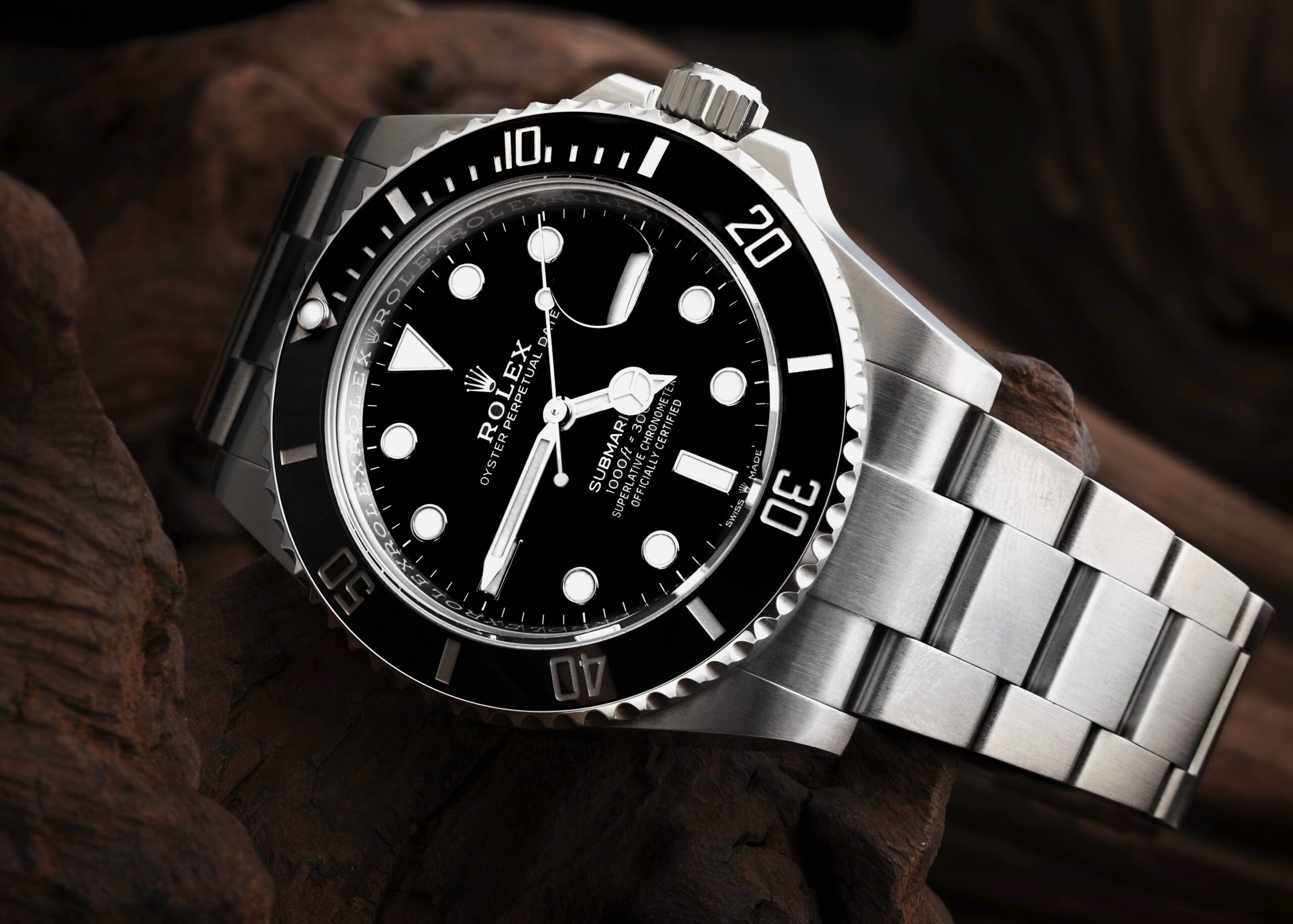 Close-up of the Rolex Submariner 126610 on a wood surface, showing its black dial, unidirectional ceramic bezel, and robust Oystersteel bracelet.