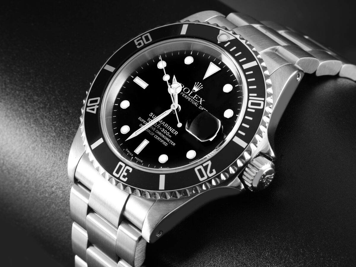 Close-up of the iconic Rolex Submariner watch with a black dial and bezel, representing the enduring design of 20th-century tool watches.