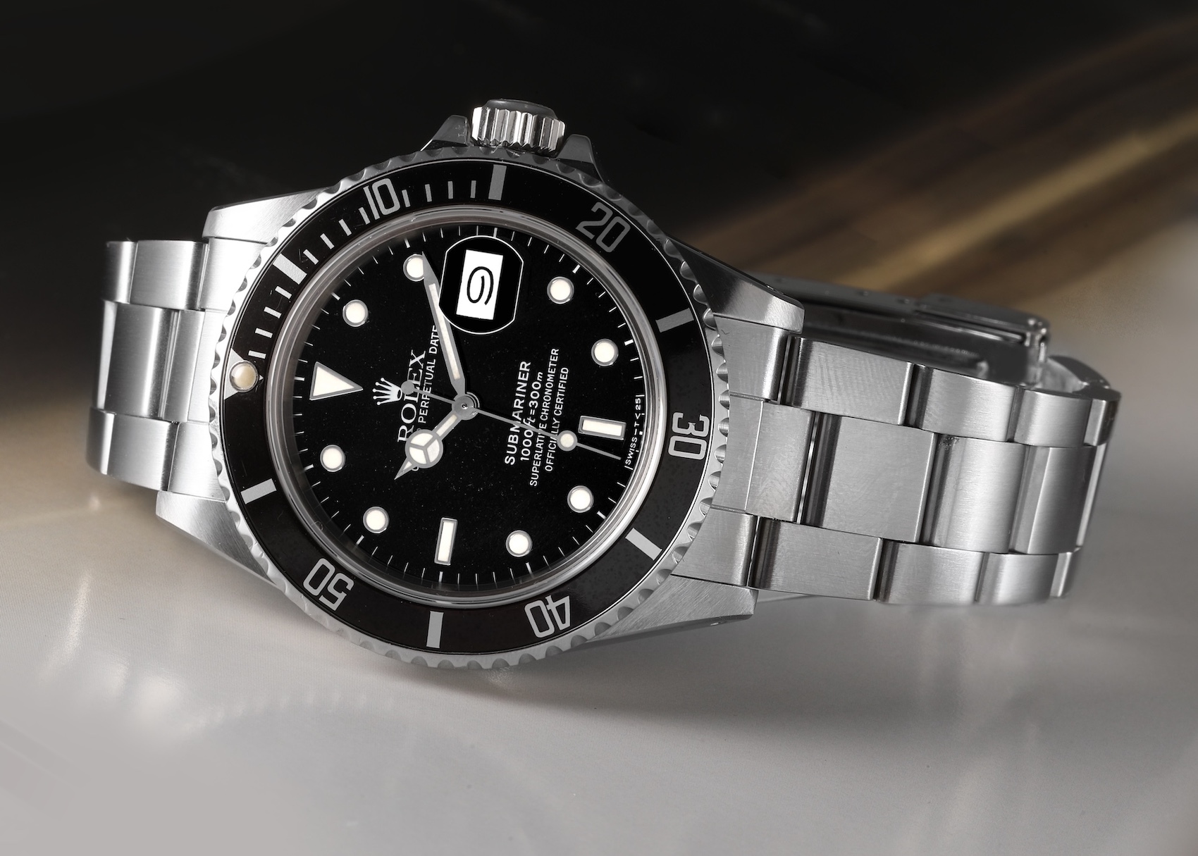 A vintage Rolex Submariner 1680, a stainless steel watch with a black dial, a date window, and a unidirectional rotating black bezel, is photographed up close.
