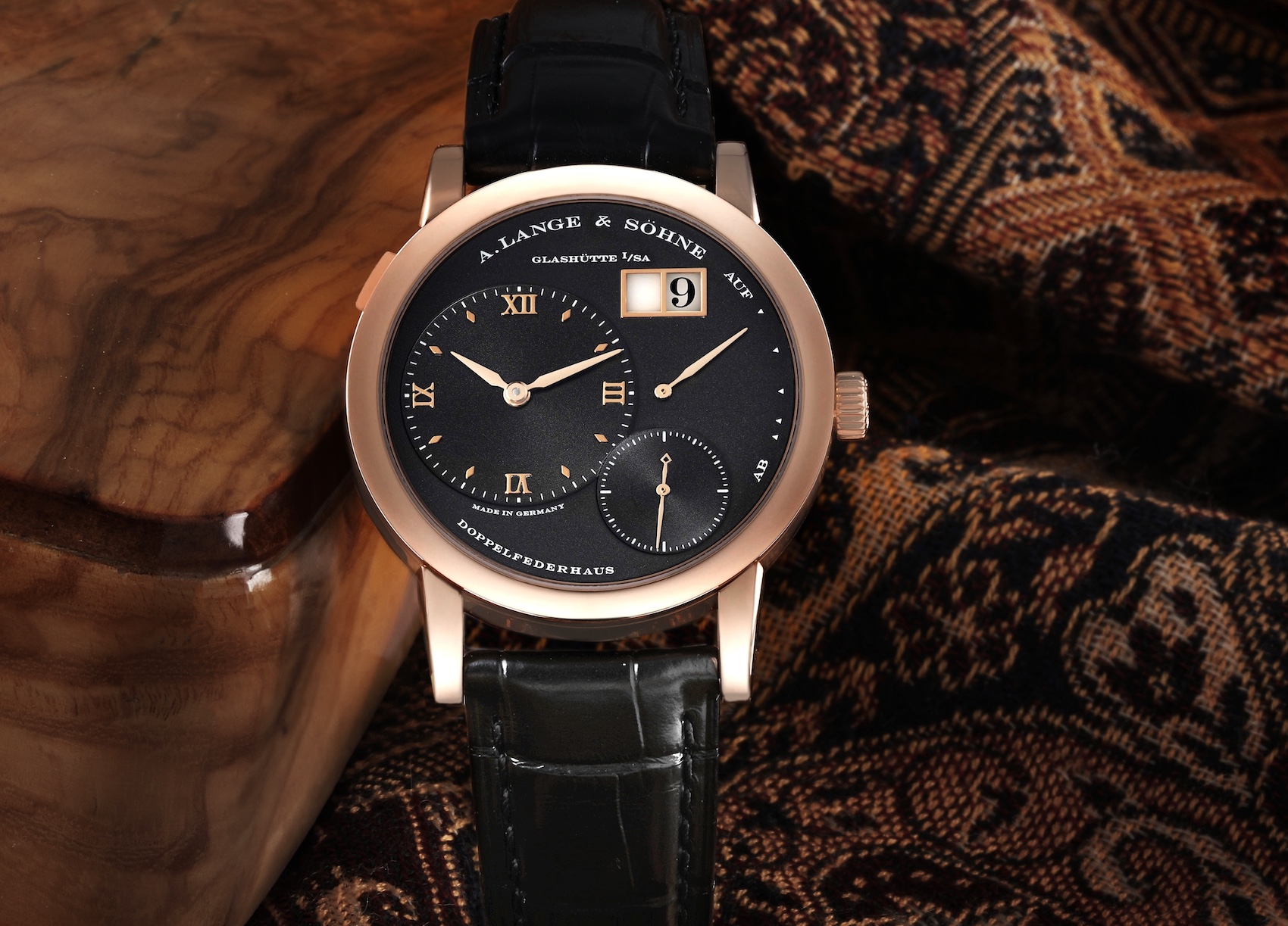 A detailed shot of the A. Lange & Söhne Lange 1 in rose gold, highlighting the warm tones of the case against the deep black dial.