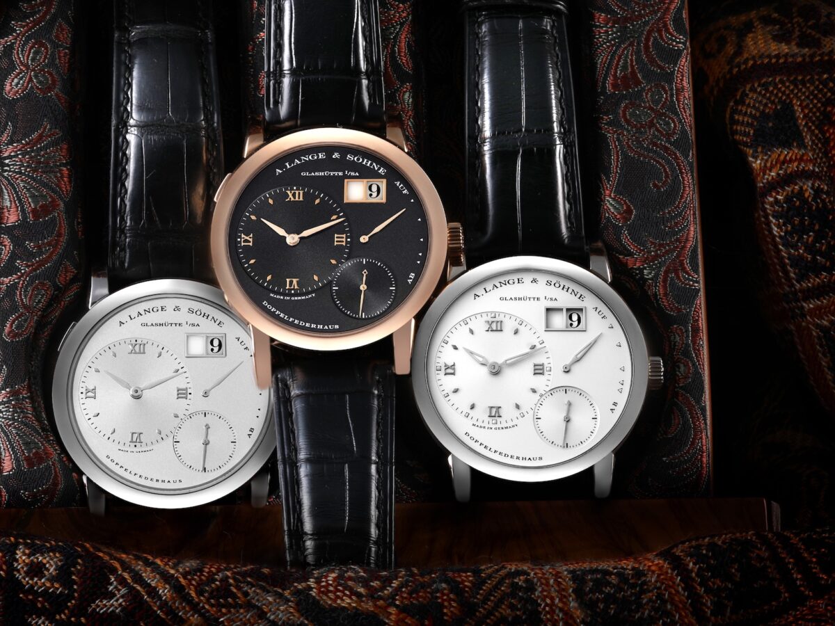 Three A. Lange & Söhne Lange 1 watches displayed together, showing the different variations of this iconic model, including rose gold and white gold cases.