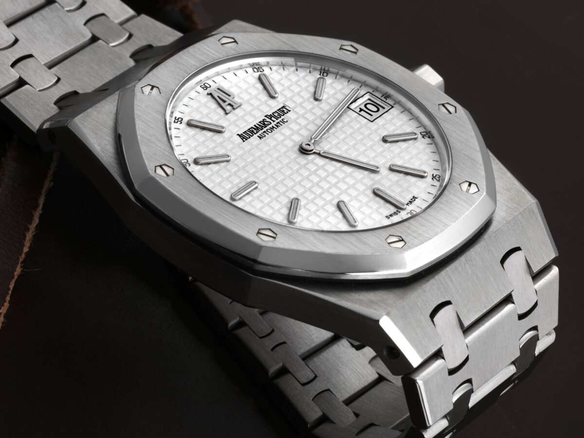 Close-up of a classic steel Audemars Piguet Royal Oak watch with its iconic octagonal bezel and a white Grande Tapisserie dial.