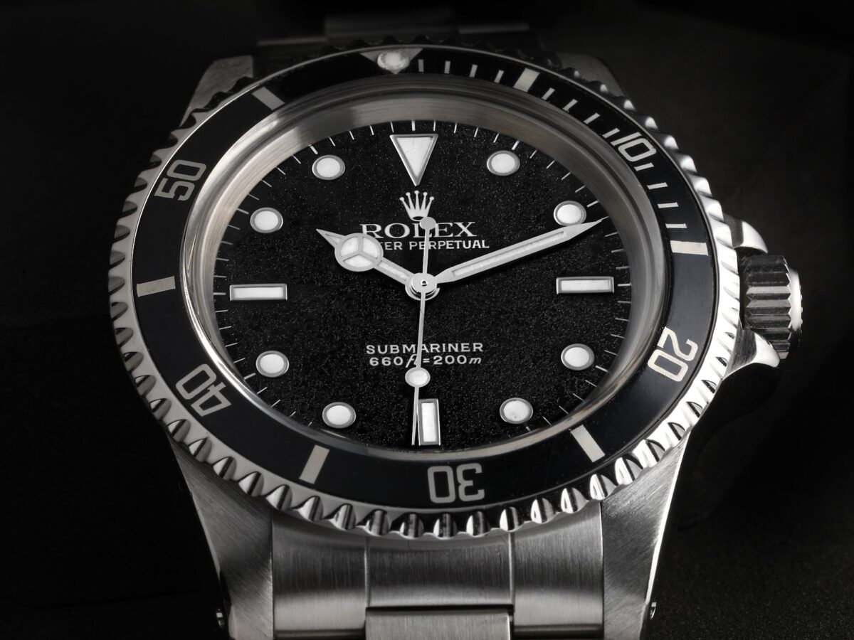 Close-up of a vintage stainless steel Rolex Submariner 5513 with a unique frosted or matte black dial and black bezel.