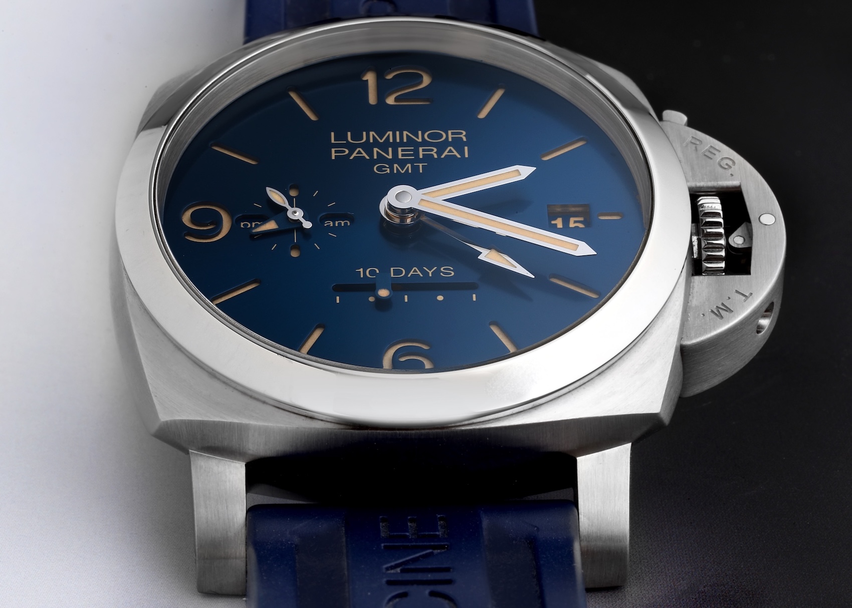 A Panerai Luminor GMT PAM00986 watch featuring a stainless steel cushion-shaped case with the signature crown-protecting device. The dial is a deep blue with luminous markers, a date window, and a small seconds/am-pm indicator.