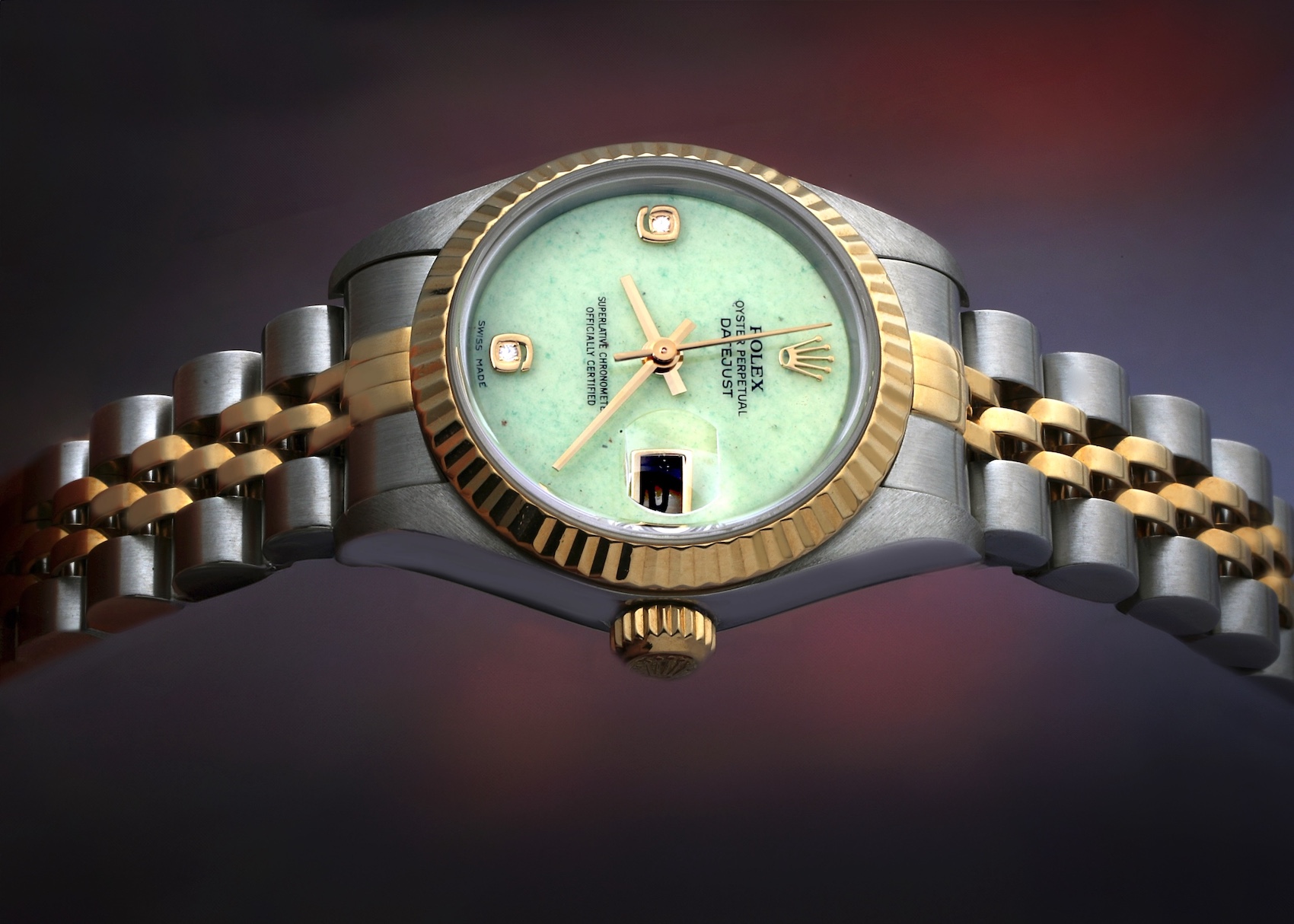 A two-tone Rolex Lady-Datejust with a yellow gold fluted bezel, Jubilee bracelet, and a unique pale green jadeite stone dial set with diamond hour markers.