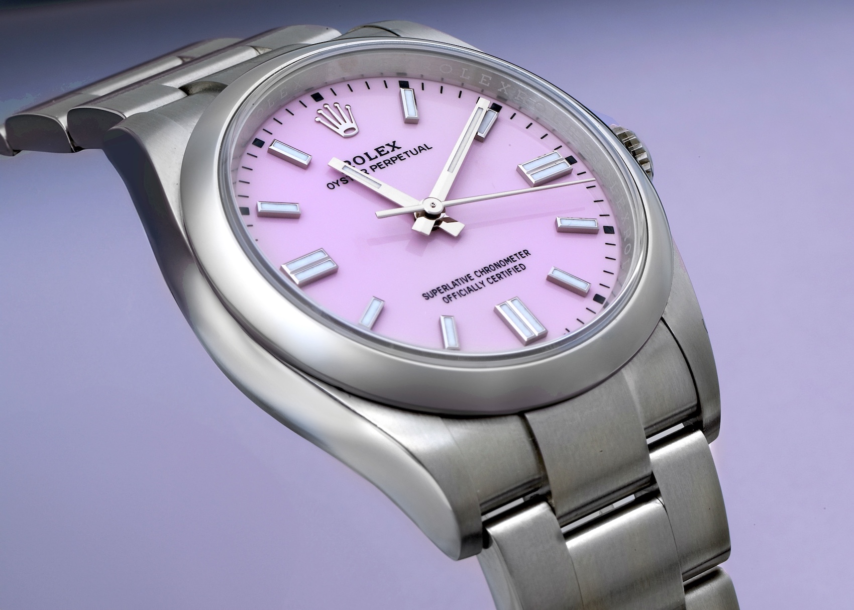 A Rolex Oyster Perpetual watch in stainless steel, featuring a vibrant candy pink dial, simple stick hour markers, and a classic Oyster bracelet.