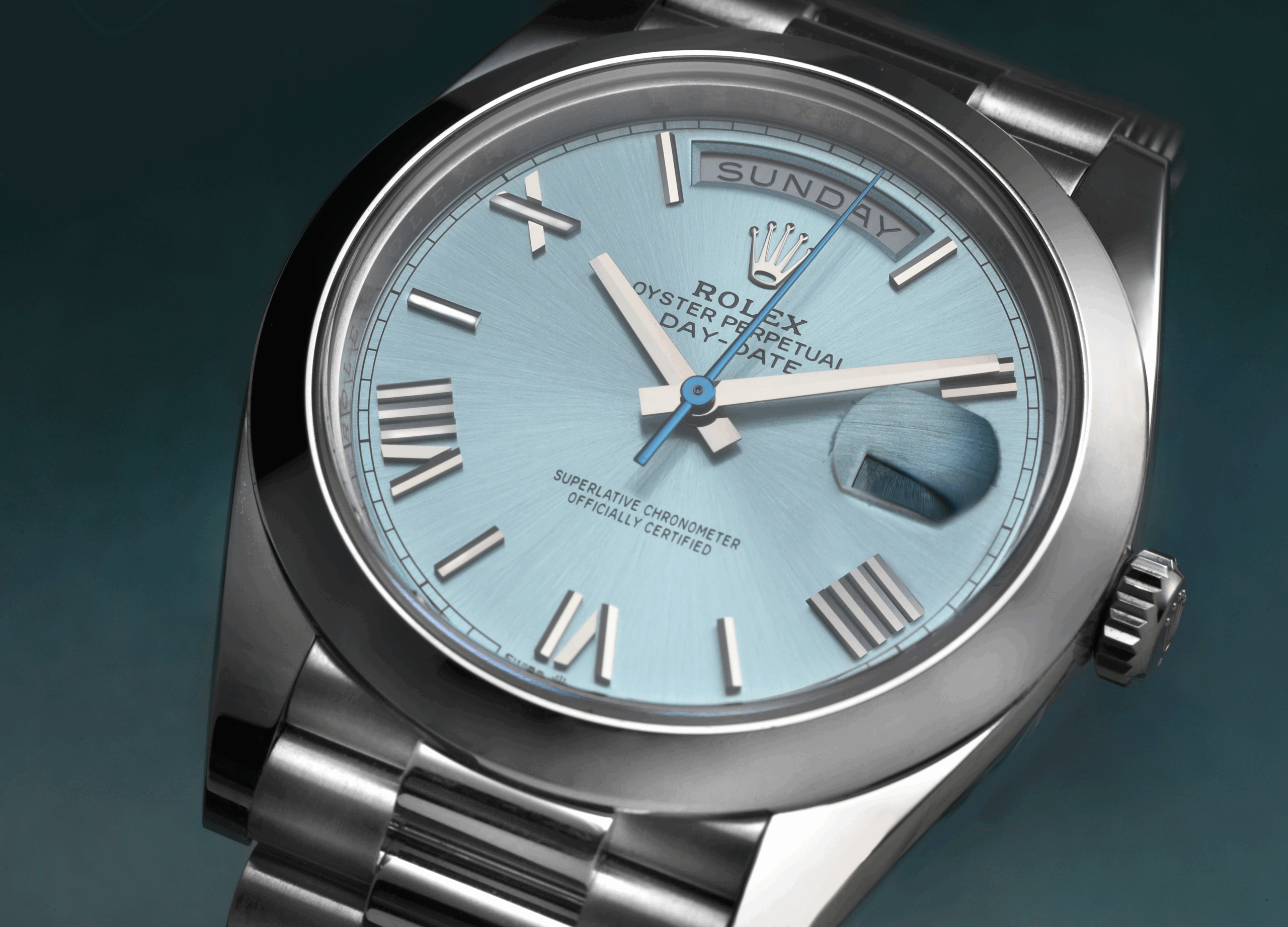 A detailed macro shot of a prestigious platinum Rolex Day-Date with an ice blue dial, clearly displaying the "IIII" for the number four.