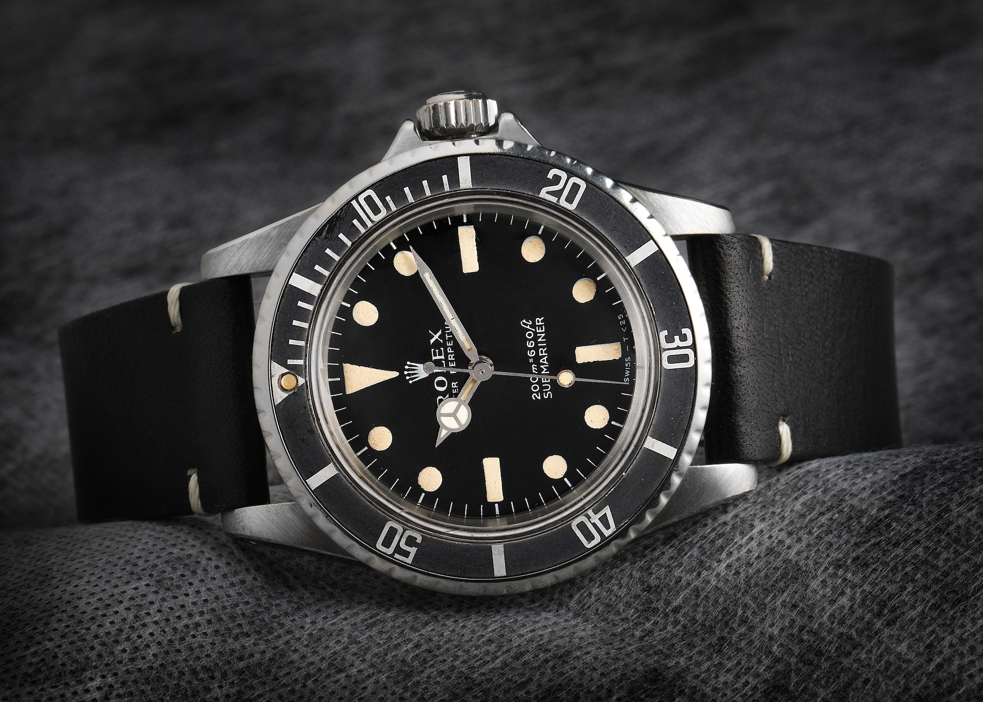 A vintage Rolex Submariner reference 5512, the same model worn by Steve McQueen, featuring a black dial with a warm, aged patina on the hour markers.