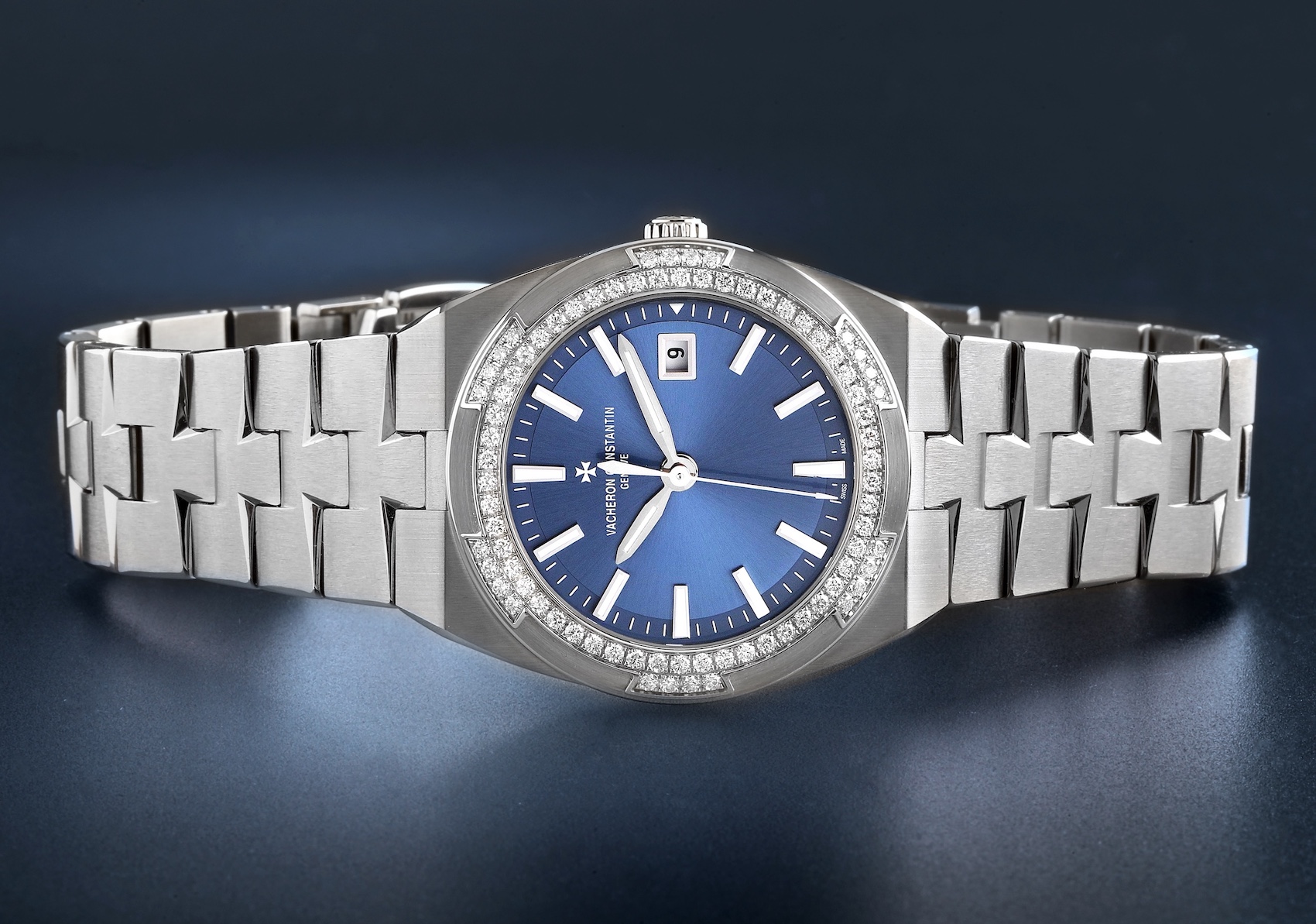 The Vacheron Constantin Overseas ladies' watch, featuring a steel case, a brilliant diamond-set bezel, a striking blue dial, and its signature Maltese cross-inspired integrated bracelet.