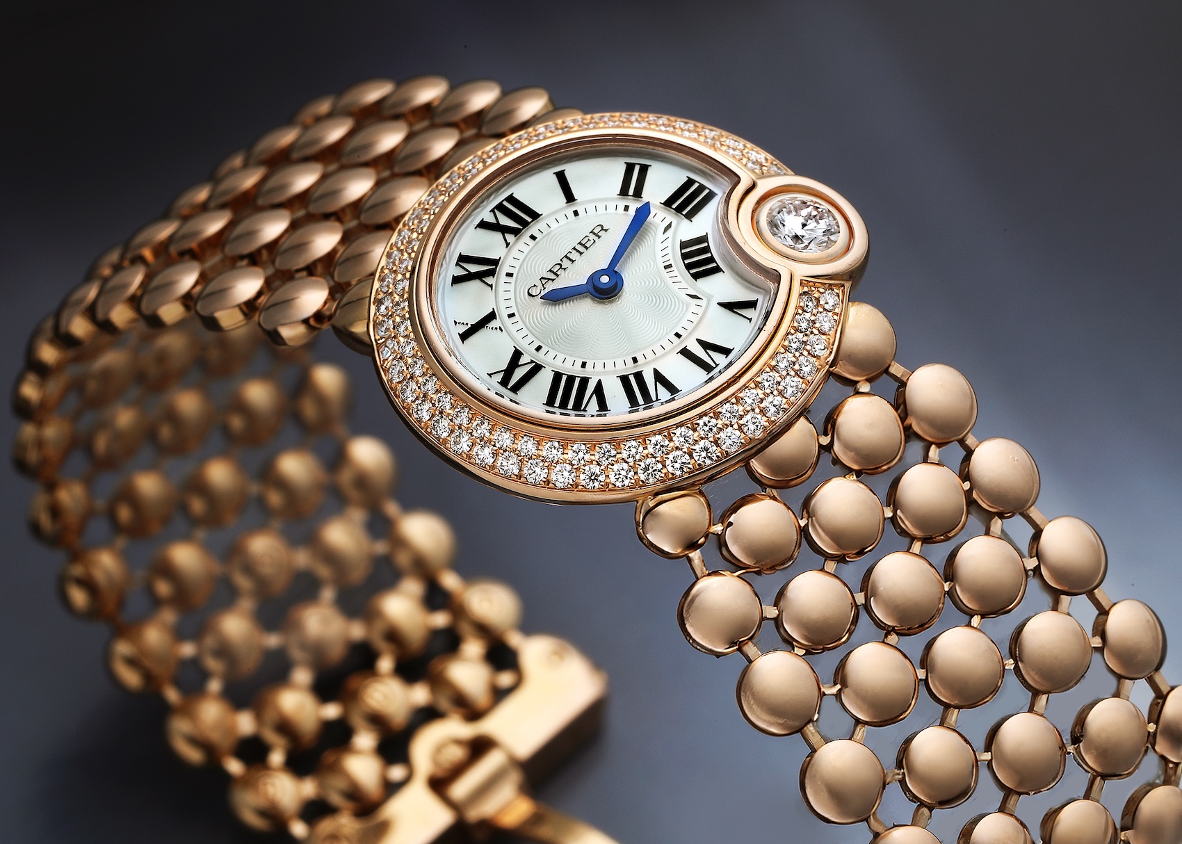 A Cartier Ballon Blanc de Cartier WE902057 in rose gold, featuring its signature pebble-link bracelet, diamond bezel, and a prominent solitaire diamond set at 4 o'clock.