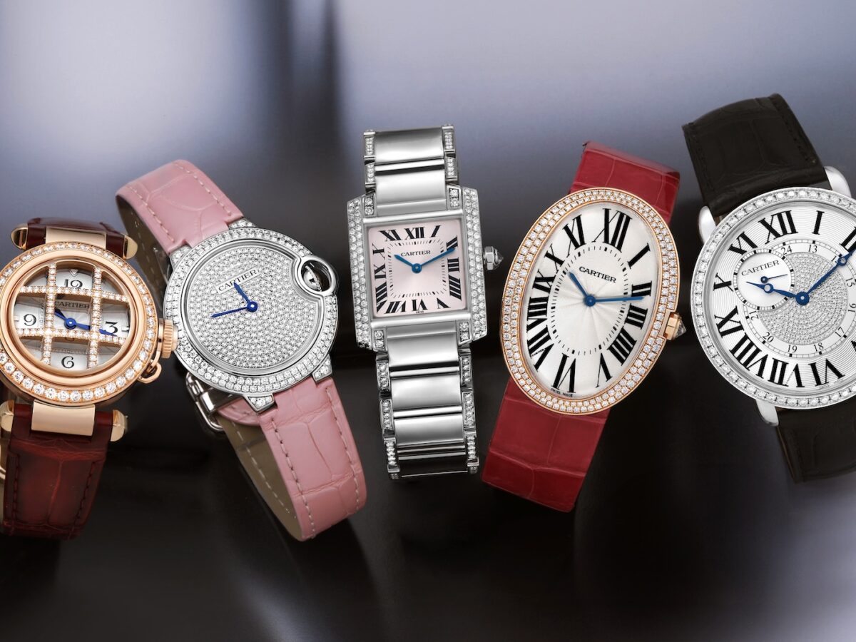 A lineup of five different Cartier ladies' watches from the holiday gift guide, showcasing a variety of styles from round to rectangular, all featuring diamonds.