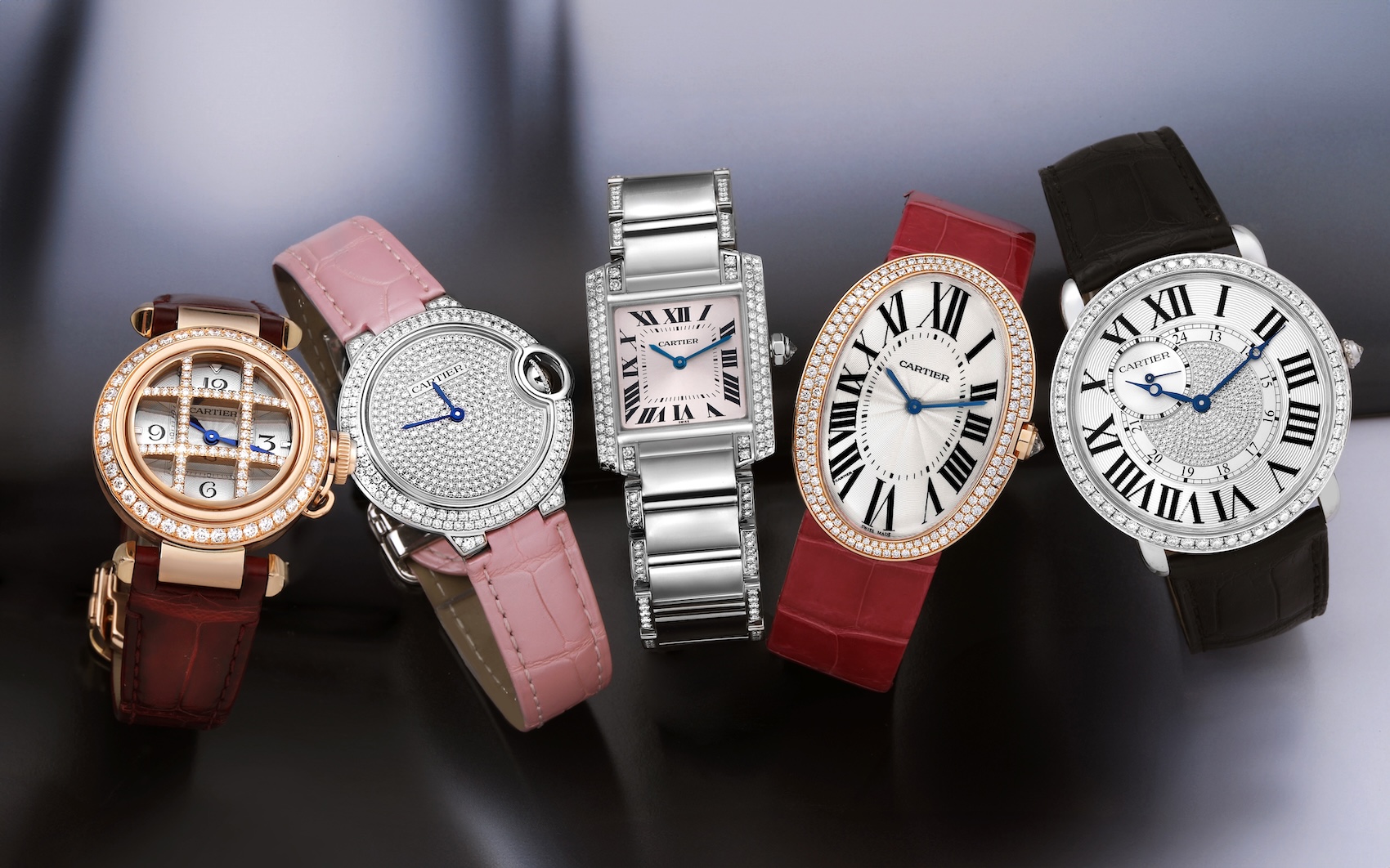A lineup of five different Cartier ladies' watches from the holiday gift guide, showcasing a variety of styles from round to rectangular, all featuring diamonds.