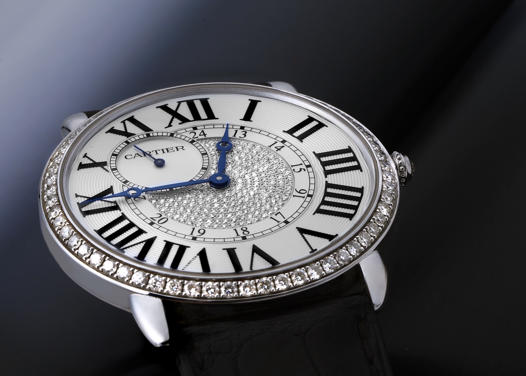 The Cartier Ronde Louis WR007004 watch in white gold, featuring a diamond-set bezel, a pavé diamond center dial, and a small seconds sub-dial, on a black leather strap.