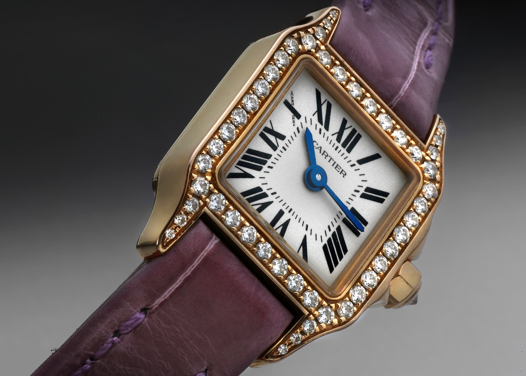 The Cartier Santos Demoiselle Mini WF902004 watch, featuring a rose gold square case set with diamonds, on a vibrant purple leather strap.