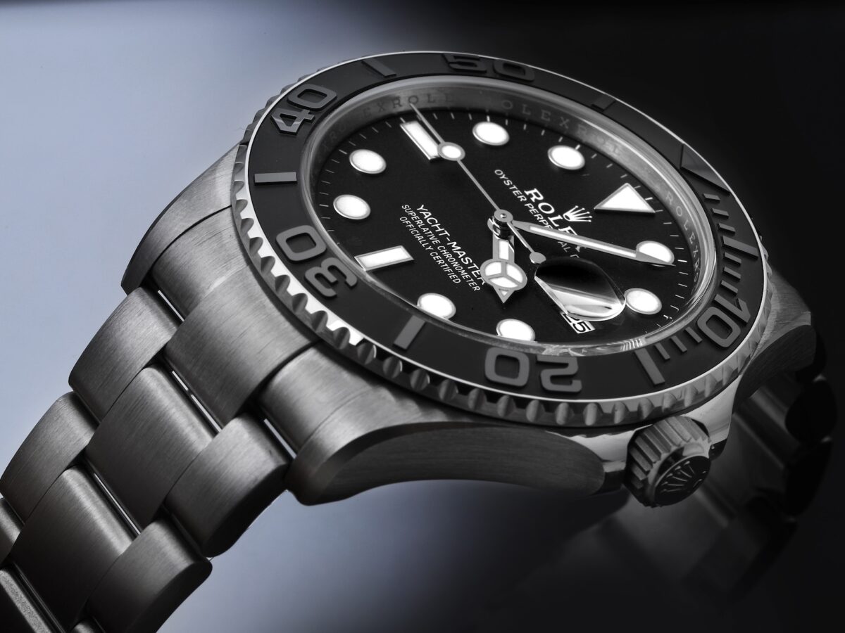 An angled profile of the Rolex Yacht-Master 42 in RLX Titanium, highlighting the technical satin-brushed finish on the watch case and Oyster bracelet against a dark background.