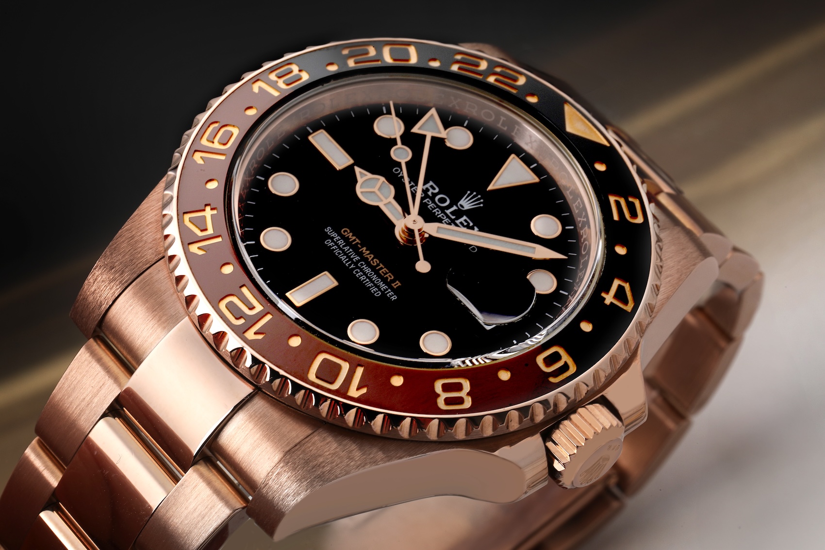 A luxury Rolex GMT-Master II "Root Beer" watch crafted from solid 18k Everose gold, featuring a brown and black ceramic bezel.