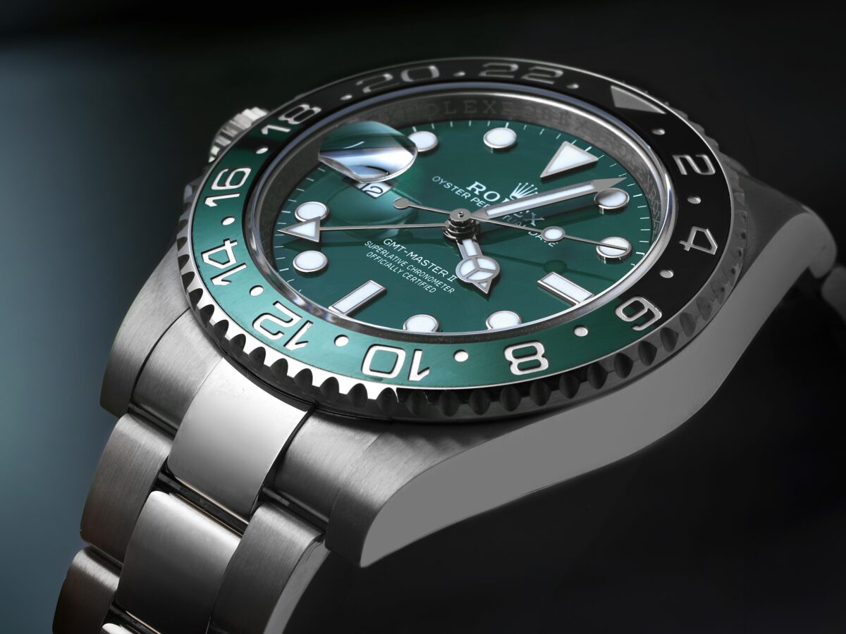 A detailed, angled photograph of the white gold Rolex GMT-Master II Sprite, focusing on the gloss of the green dial and the bi-colored green and black ceramic bezel.