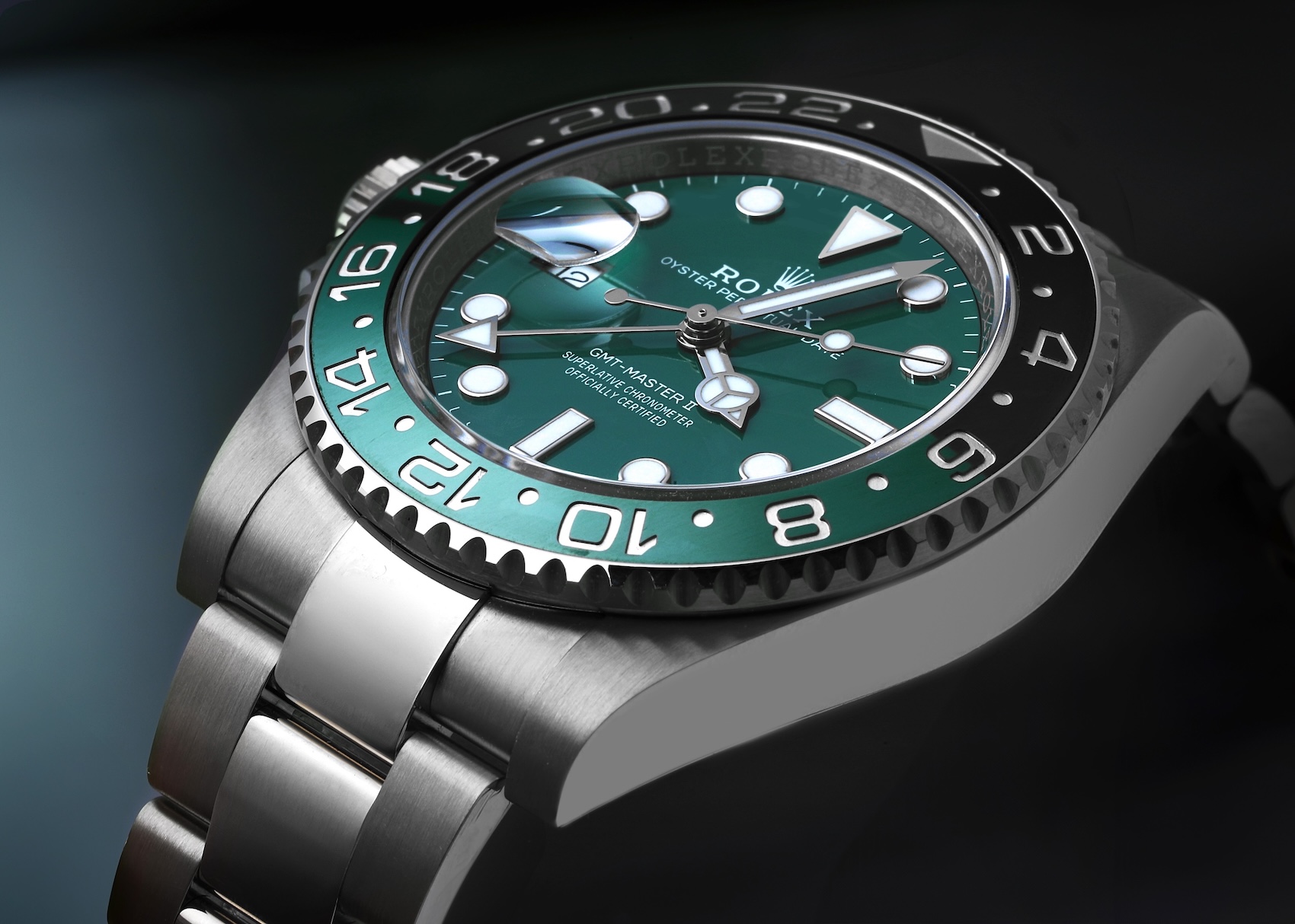 A close-up of a Rolex GMT-Master II, showcasing its distinctive two-tone green and black Cerachrom bezel.