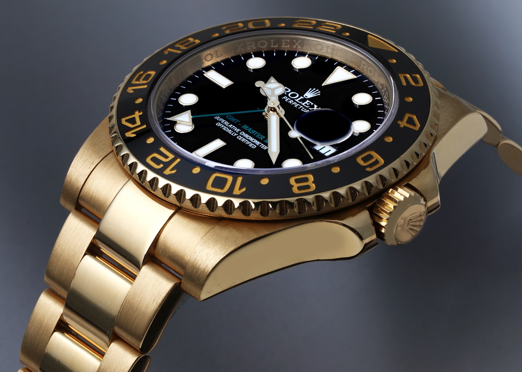 An all-yellow gold Rolex GMT-Master II featuring a black ceramic bezel with gold-filled numerals and a contrasting green GMT hand.