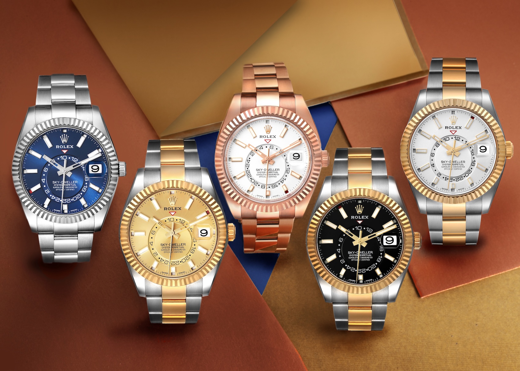 A collection of five different Rolex Sky-Dweller watches, showcasing various models in stainless steel, Everose gold, and two-tone Rolesor, with blue, gold, black, and white dials.