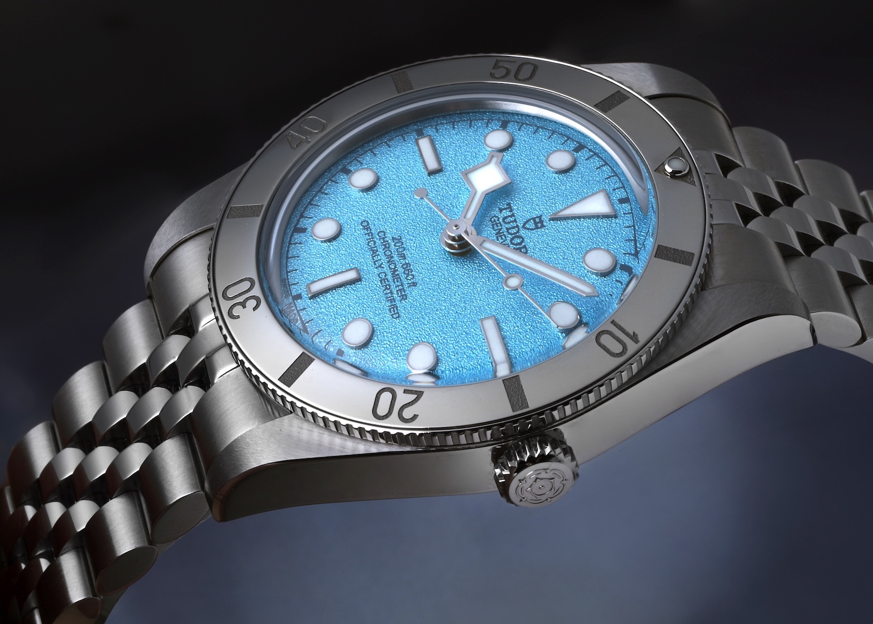 A close-up shot of the Tudor Black Bay Fifty-Four (BB54) featuring a 'Lagoon Blue' textured dial and a five-link bracelet.