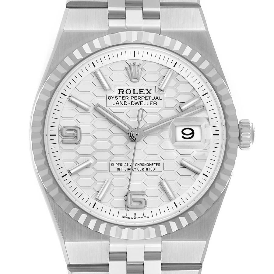 A direct, face-on macro shot of the Rolex Land-Dweller dial. The image details the white honeycomb pattern, the Rolex crown logo, the date window at 3 o'clock, and the text "OYSTER PERPETUAL LAND-DWELLER".