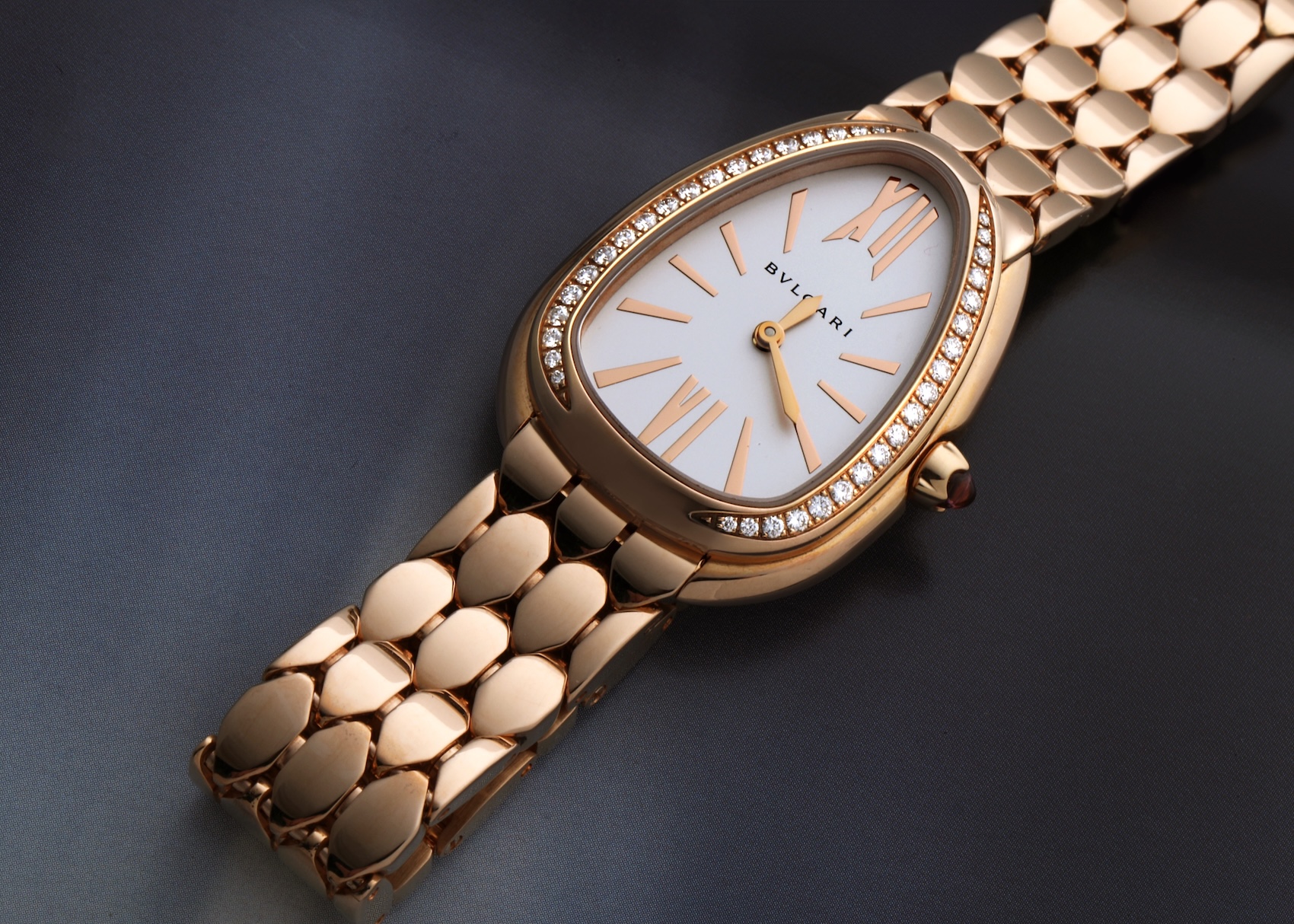 Flat lay of Bvlgari Serpenti Seduttori watch in 18k rose gold featuring a diamond-set bezel and white silver opaline dial.