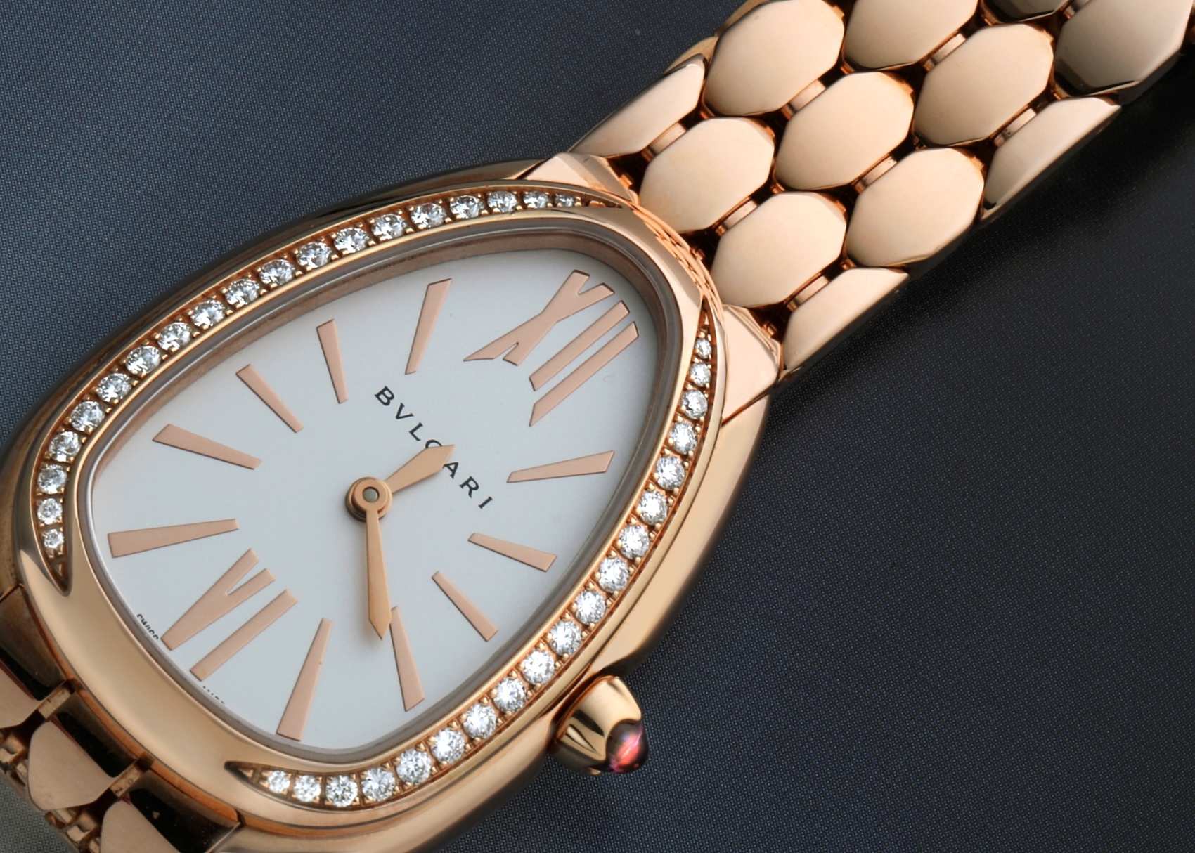 Angled view of Bvlgari Serpenti Seduttori highlighting the pink rubellite cabochon crown and rose gold hands.