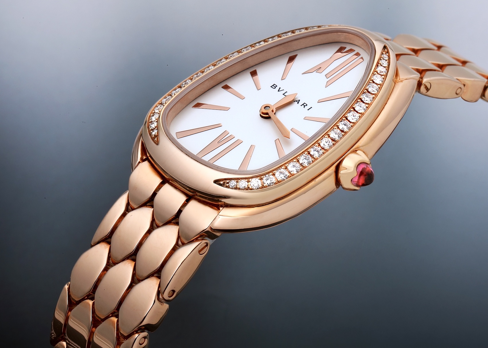 The Bvlgari Serpenti Seduttori in 18k rose gold, shown at an angle to highlight the diamond-set, drop-shaped case, white opaline dial, and signature flexible scale-like bracelet.