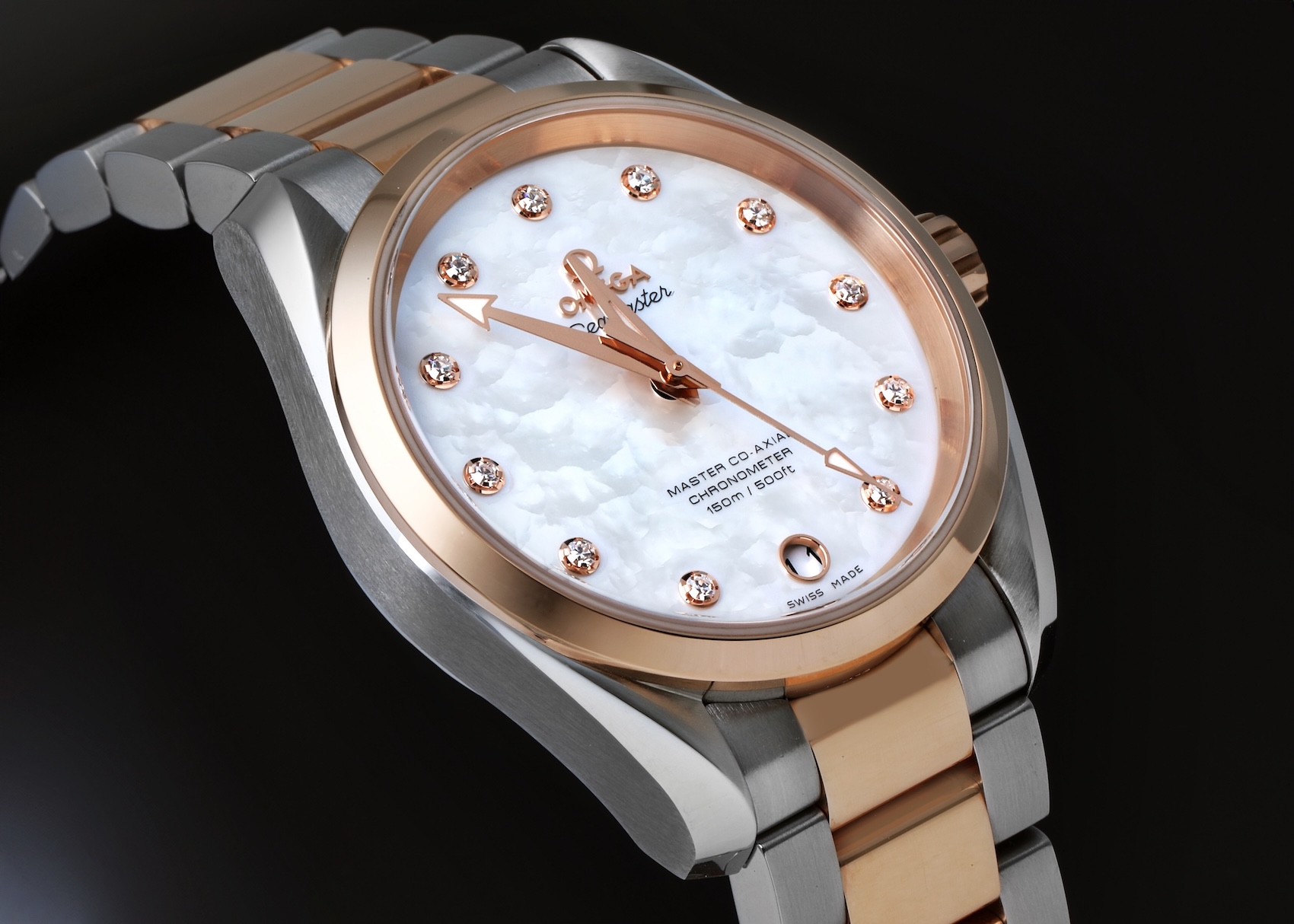 A ladies' Omega Seamaster Aqua Terra in steel and 18k rose gold, angled to show the luminous white mother-of-pearl dial which is set with 11 diamond hour markers.