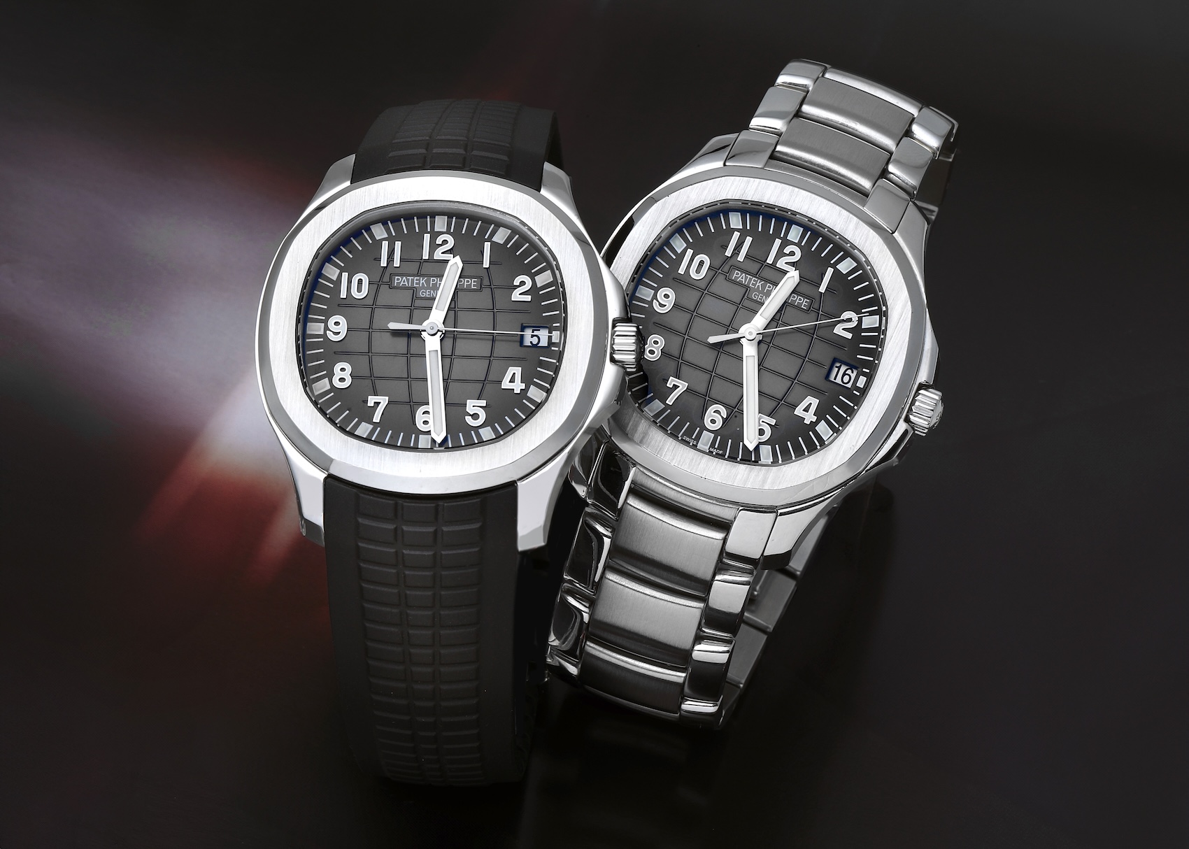 Two Patek Philippe Aquanaut ref 5167 models in stainless steel. One model is presented on the signature black "Tropical" composite strap, and the other is paired with a matching stainless steel bracelet.