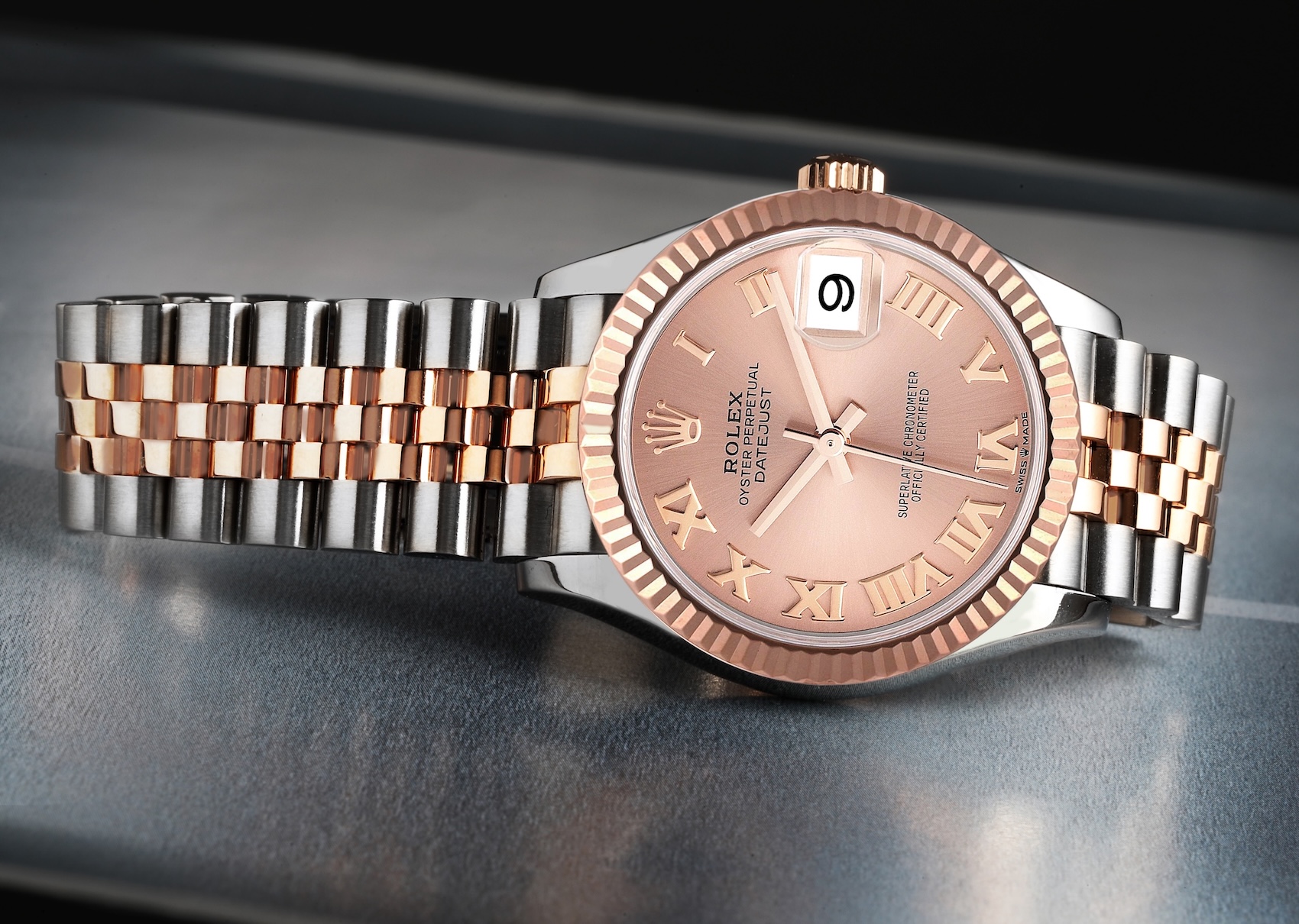  A Rolex Datejust 31 (278271) in steel and Everose gold, featuring a rose-colored dial with Roman numerals, a fluted bezel, and a two-tone Jubilee bracelet.