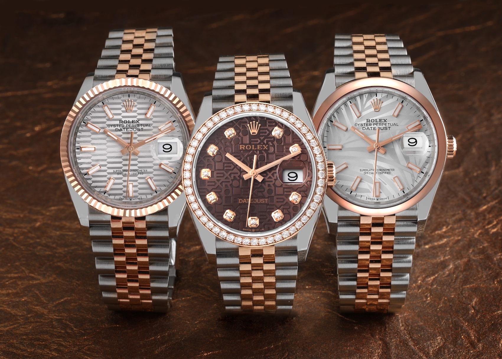 A collection of three two-tone Rolex Datejust watches in Steel and 18k Everose gold, showing different combinations of fluted and diamond-set bezels, Jubilee and Oyster bracelets.